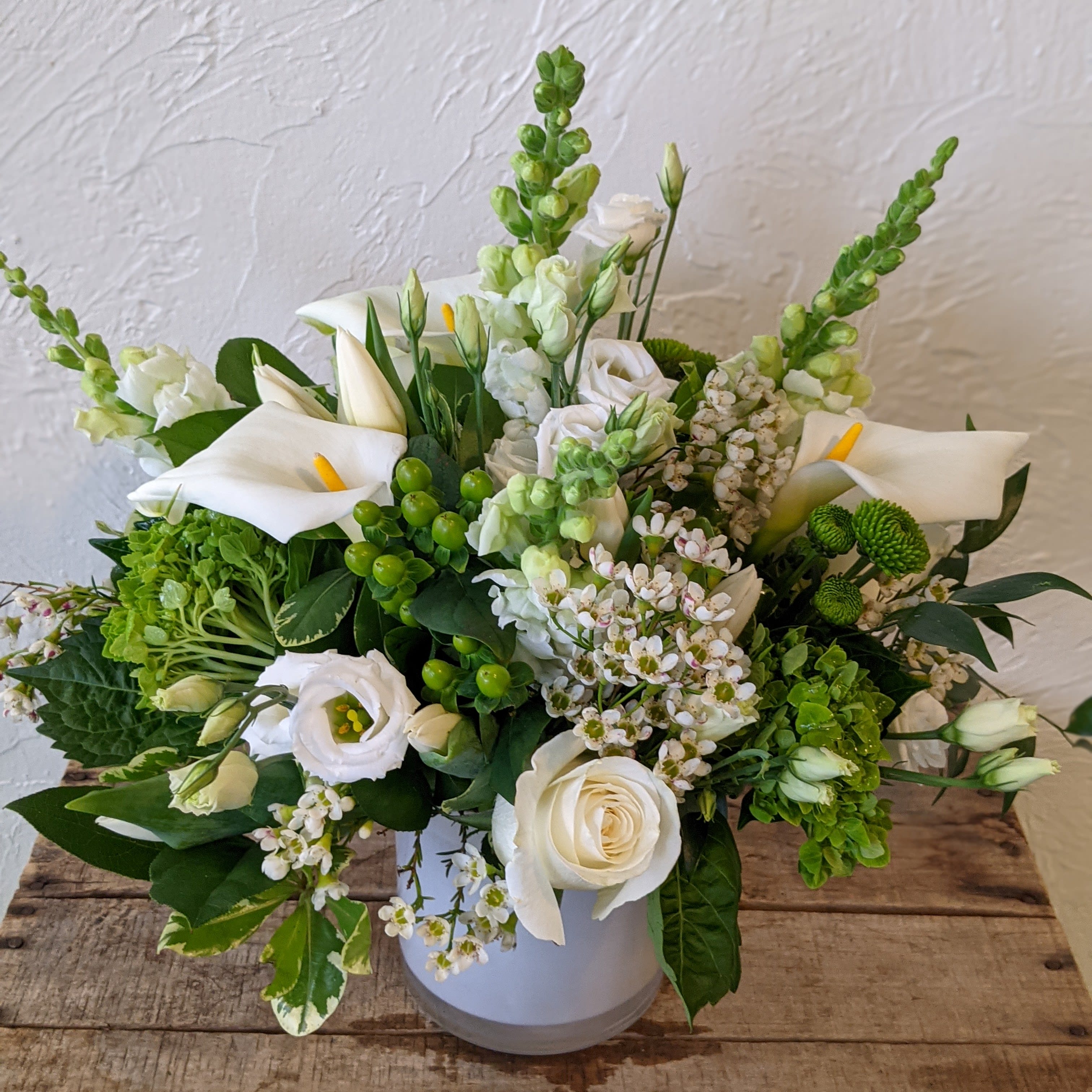 Monochrome Designer's Choice - White  - Pick the color and leave the flowers up to us with our Monochrome series Designer's Choice flower arrangements. These pieces feature a primary color pallet which we will design a beautiful arrangement of flowers around. Some accent colors may be used but the primary color scheme will designed with your chosen color in mind (Color listed in the name of this piece)  *Vase color and style may vary. Please note that the arrangement displayed in the picture is an example piece and flowers featured are not guaranteed to be replicated