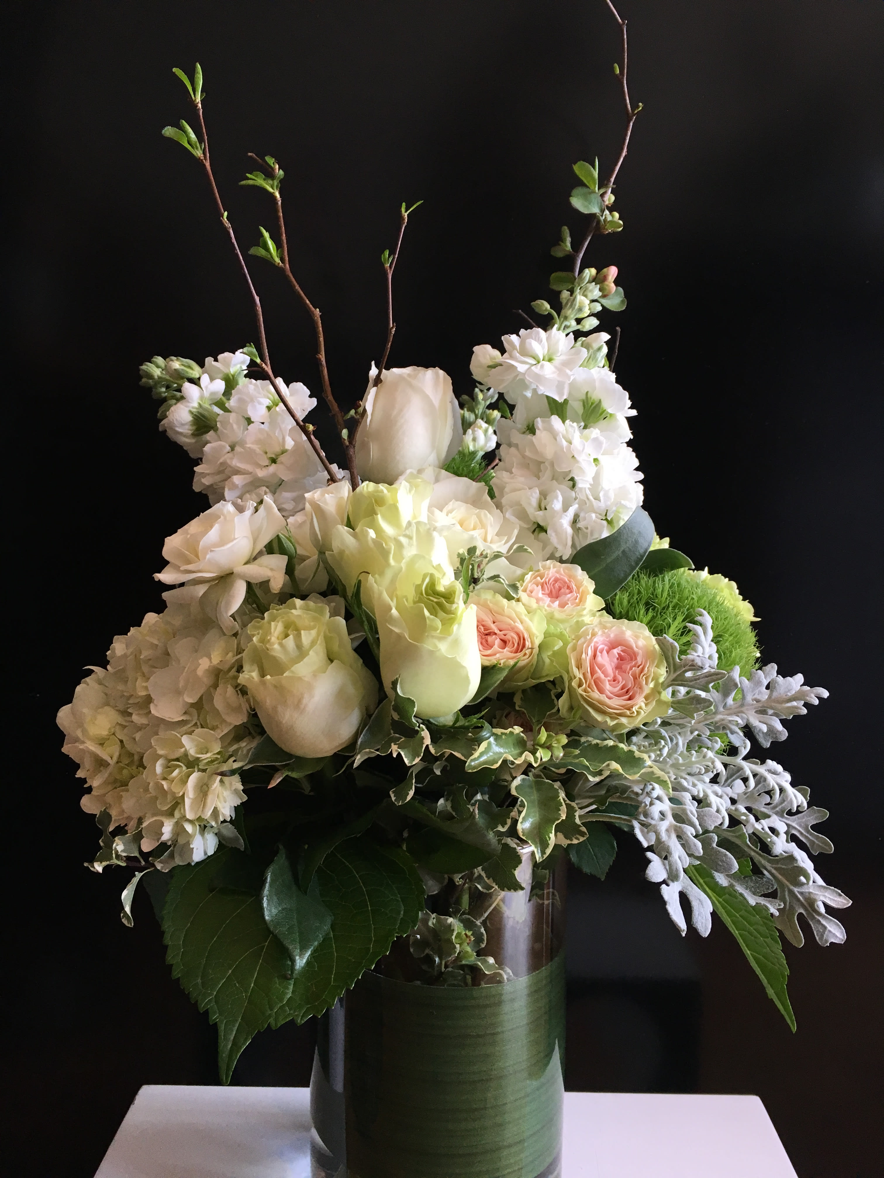 White and pale pink floral arrangement in a glass vase