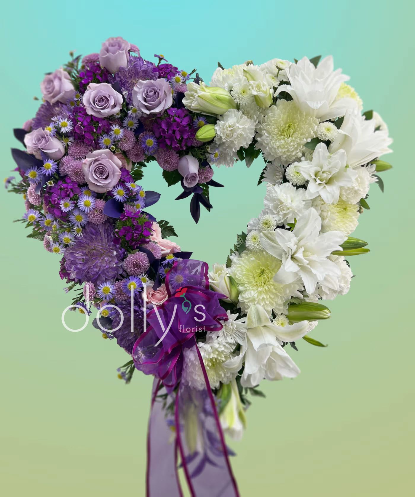 Heart-shaped bouquet of purple and white flowers with a ribbon