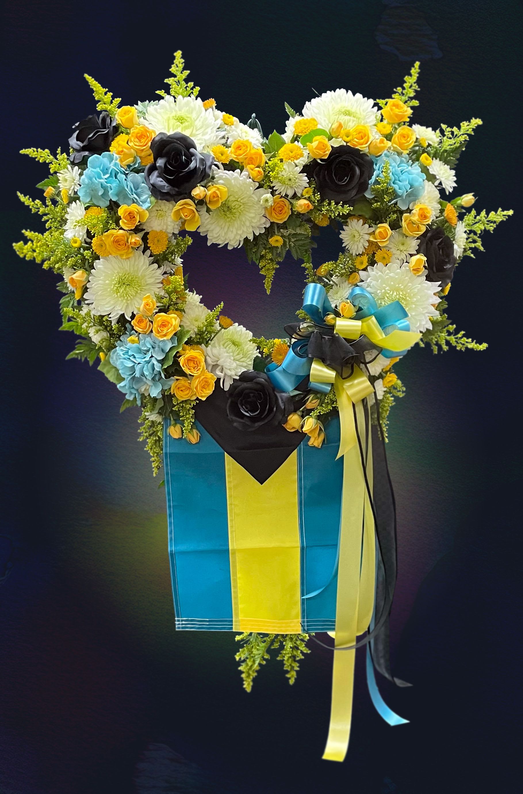 Heart-shaped floral arrangement in a blue and yellow box with ribbons