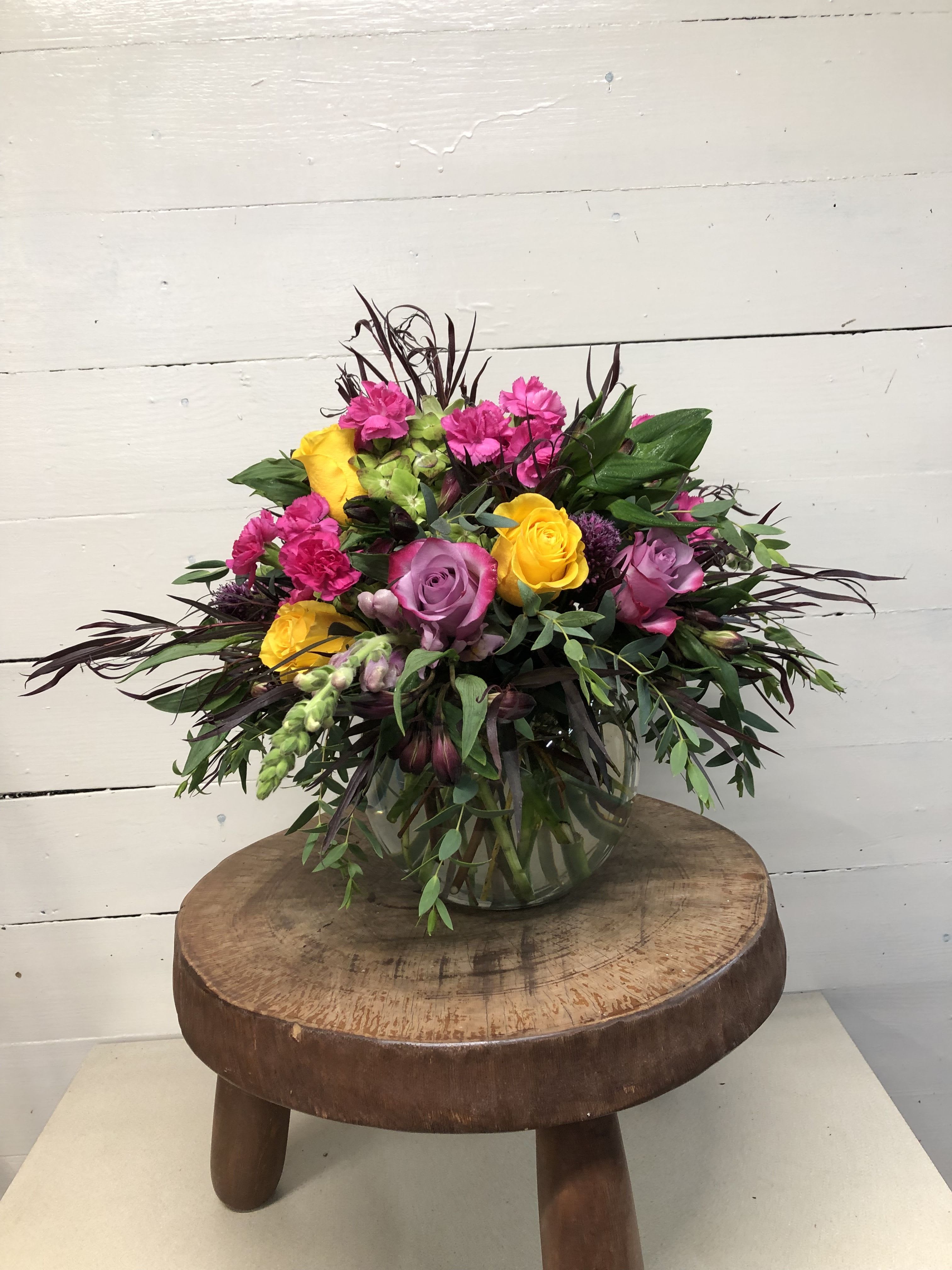 Mixed bouquet of pink and yellow roses in a glass vase