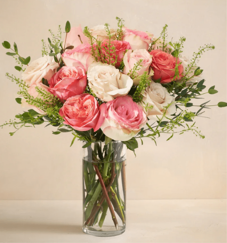 Mom's Rose Garden - Celebrate Mom with the timeless beauty of roses in full bloom. “Mom’s Rose Garden” is a lush, romantic arrangement of one dozen premium mixed roses in soft shades of blush pink, coral pink, and creamy white. The loose, rounded shape creates a full, garden-inspired look that feels both luxurious and natural — perfect for a Mother’s Day centerpiece or a heartfelt gift that says “I love you” in the most beautiful way.  