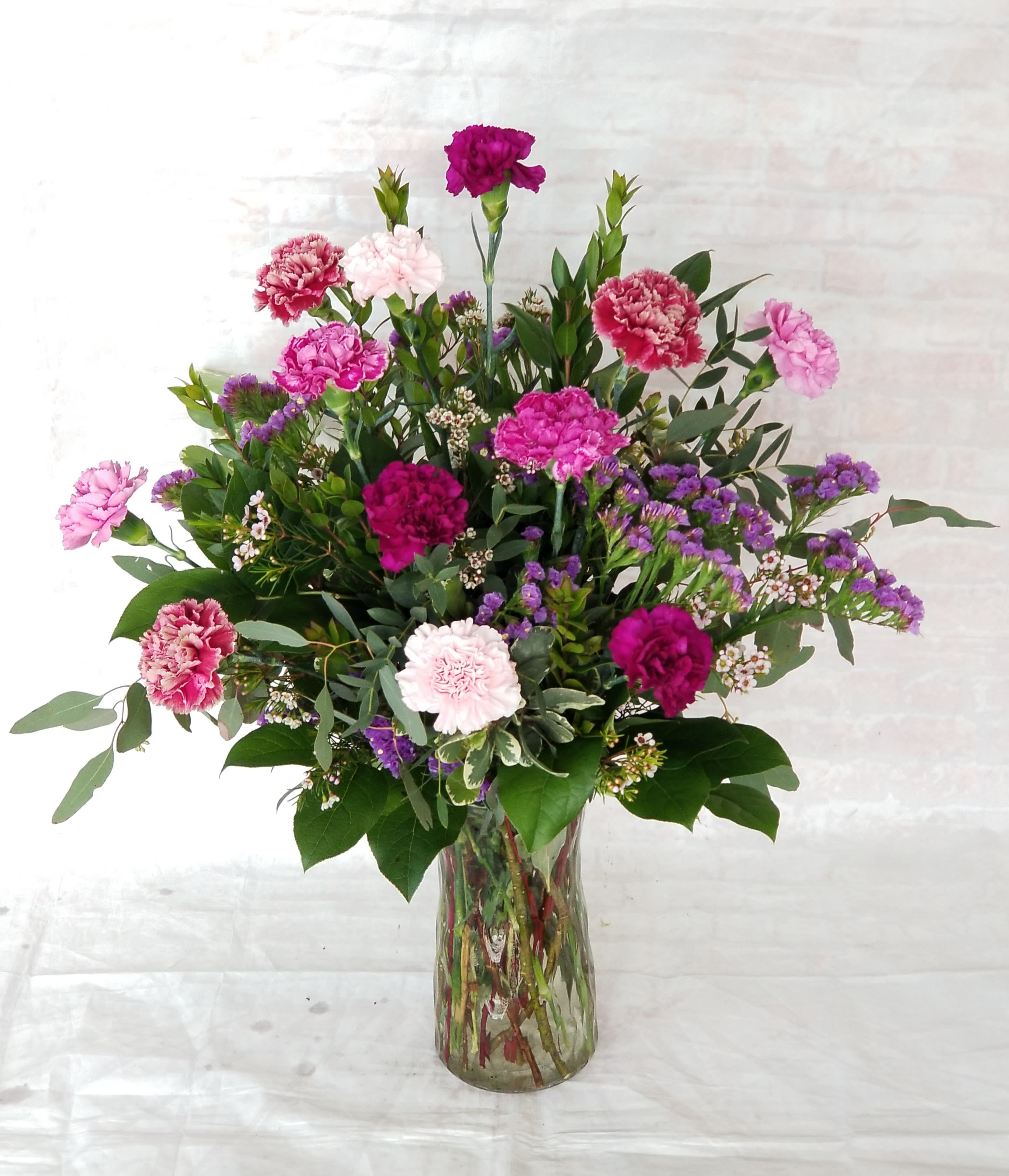 Simply Carnations - Select this full arrangement of one dozen carnations arranged in a clear glass vase.  Color may vary. Call for specific availibility or add color requests in special instructions and we will do our best to fulfill. 