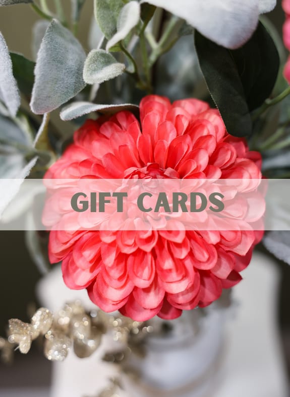 Close-up of a pink flower with soft gray-green foliage and a gift cards banner