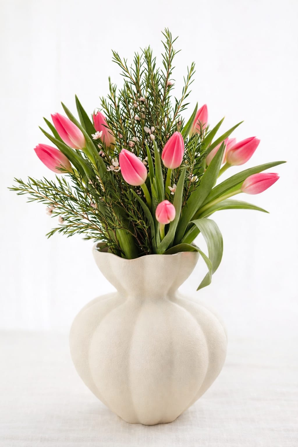 Blush Elegance Tulip  - A modern tulip arrangement in Myrtle Beach featuring soft blush pink tulips combined with fresh seasonal greenery, designed in a unique sculptural vase. This luxury flower arrangement is perfect for gifts, home décor, birthdays, and special occasions. Available for same day flower delivery in Myrtle Beach, this elegant design brings a clean, natural, and sophisticated look to any space.
