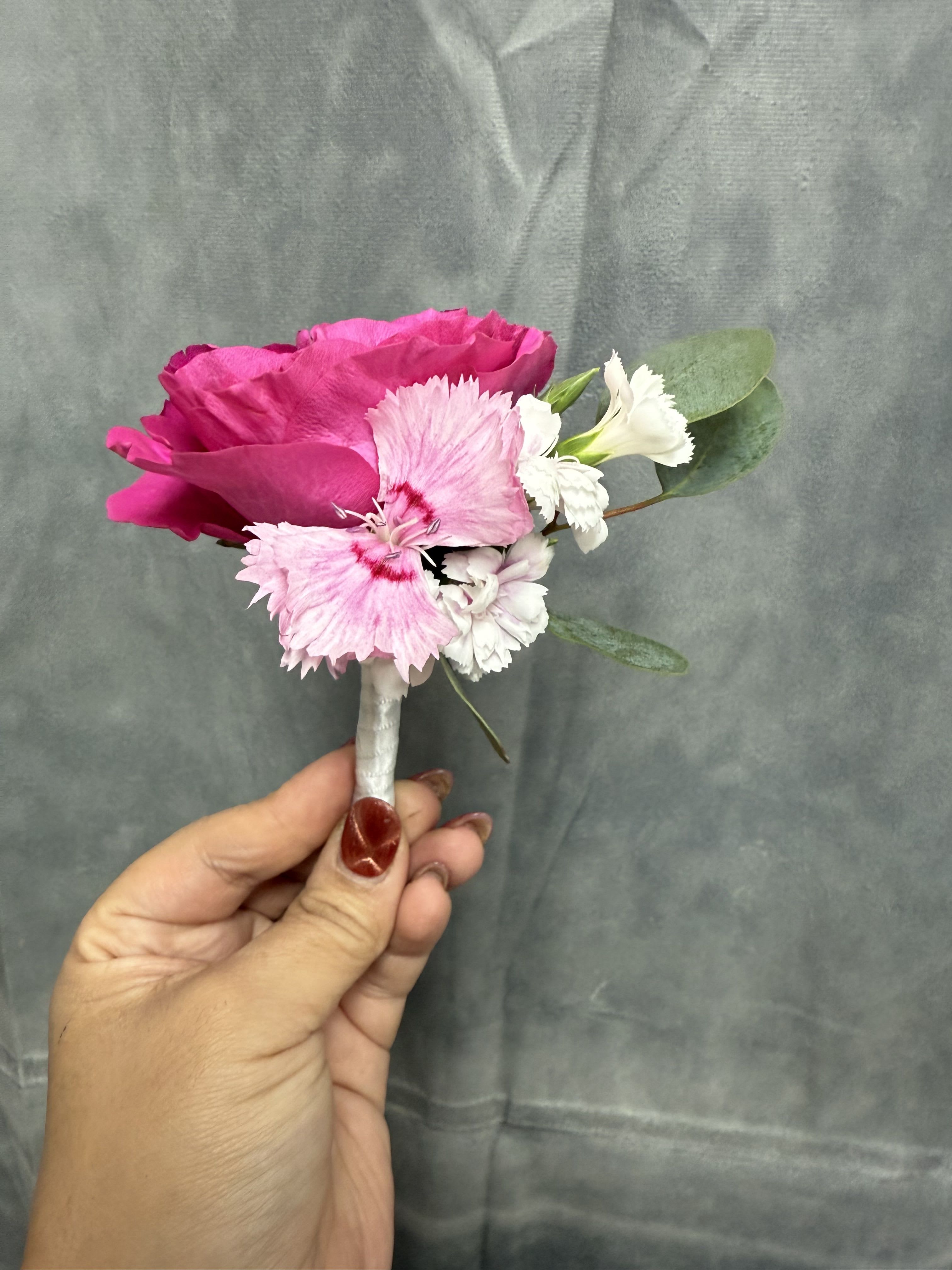 Hot pink spray roses with white boutonnière  - Hot-pink spray rose paired with pale pink and white carnations, compact hand-held boutonnière with wrapped stem.