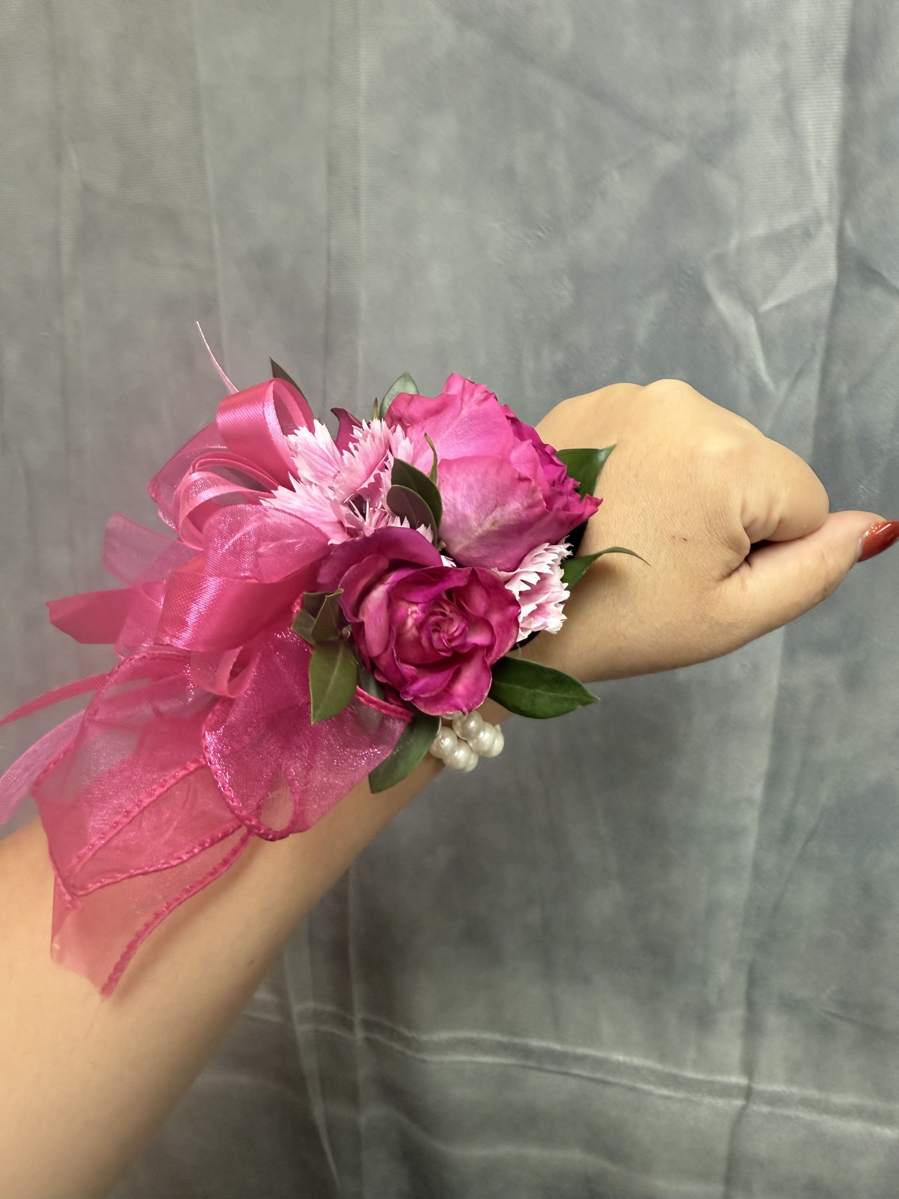Hot pink spray roses wrist corsage - Bright hot-pink roses with pink carnations, accented with organza and a glossy pink ribbon on a pearl wrist band-feminine, festive, perfect for prom