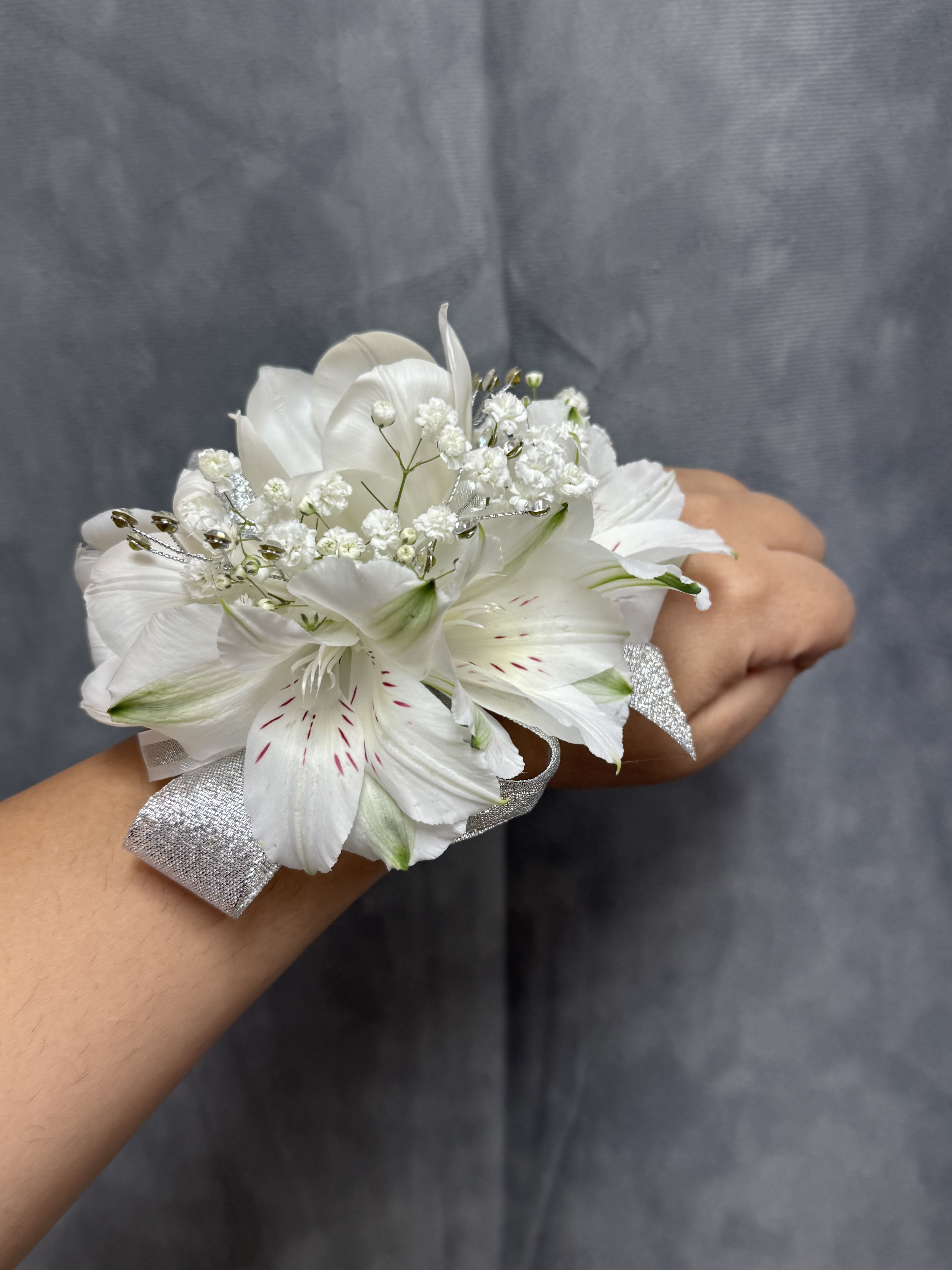 White tulips alstroemerias corsage   - White alstroemeria and tulip wrist corsage with silver ribbon, glitter and pearl wrist band , elegant for prom. The corsage can be customized upon request
