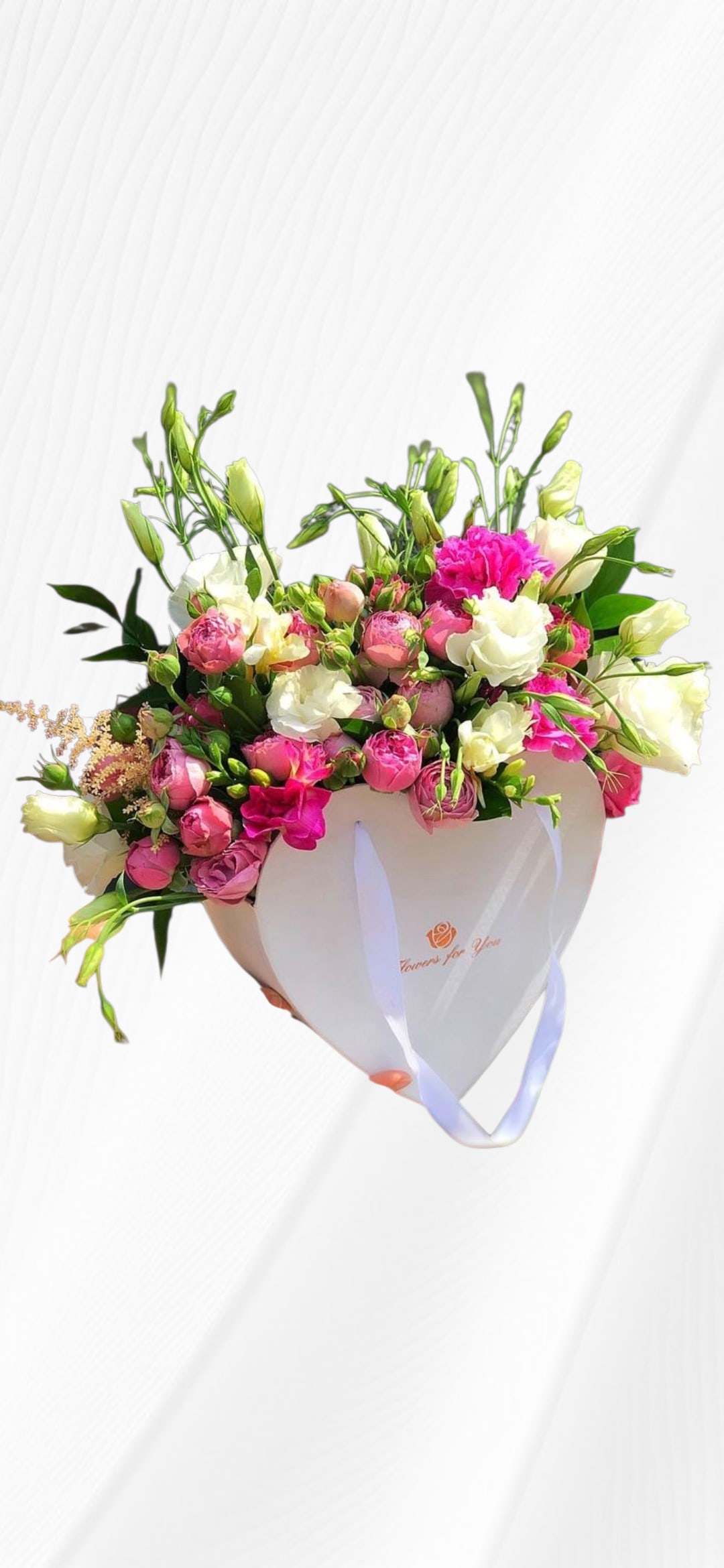 The Sweetheart Muse Arrangement - A masterpiece of love and tenderness. This elegant heart-shaped gift box features an exquisite blend of garden roses in shades of pink and magenta, accented with delicate white lisianthus.