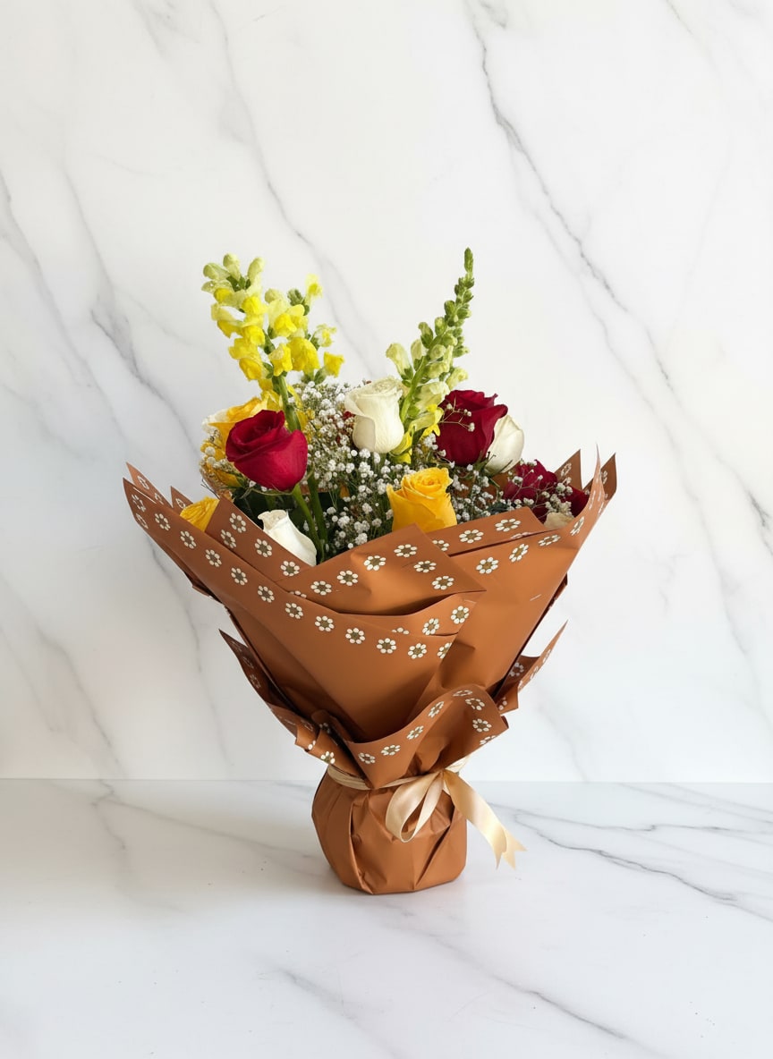 Talavera Garden - A vibrant and joyful bouquet featuring tall snapdragons, a lively mix of red, white, and yellow roses, and delicate baby’s breath for a soft, airy touch. Wrapped in Talavera-inspired paper, Talavera Garden Wrap blends bold color with artisanal charm, creating a fresh, eye-catching arrangement that feels both festive and full of life.