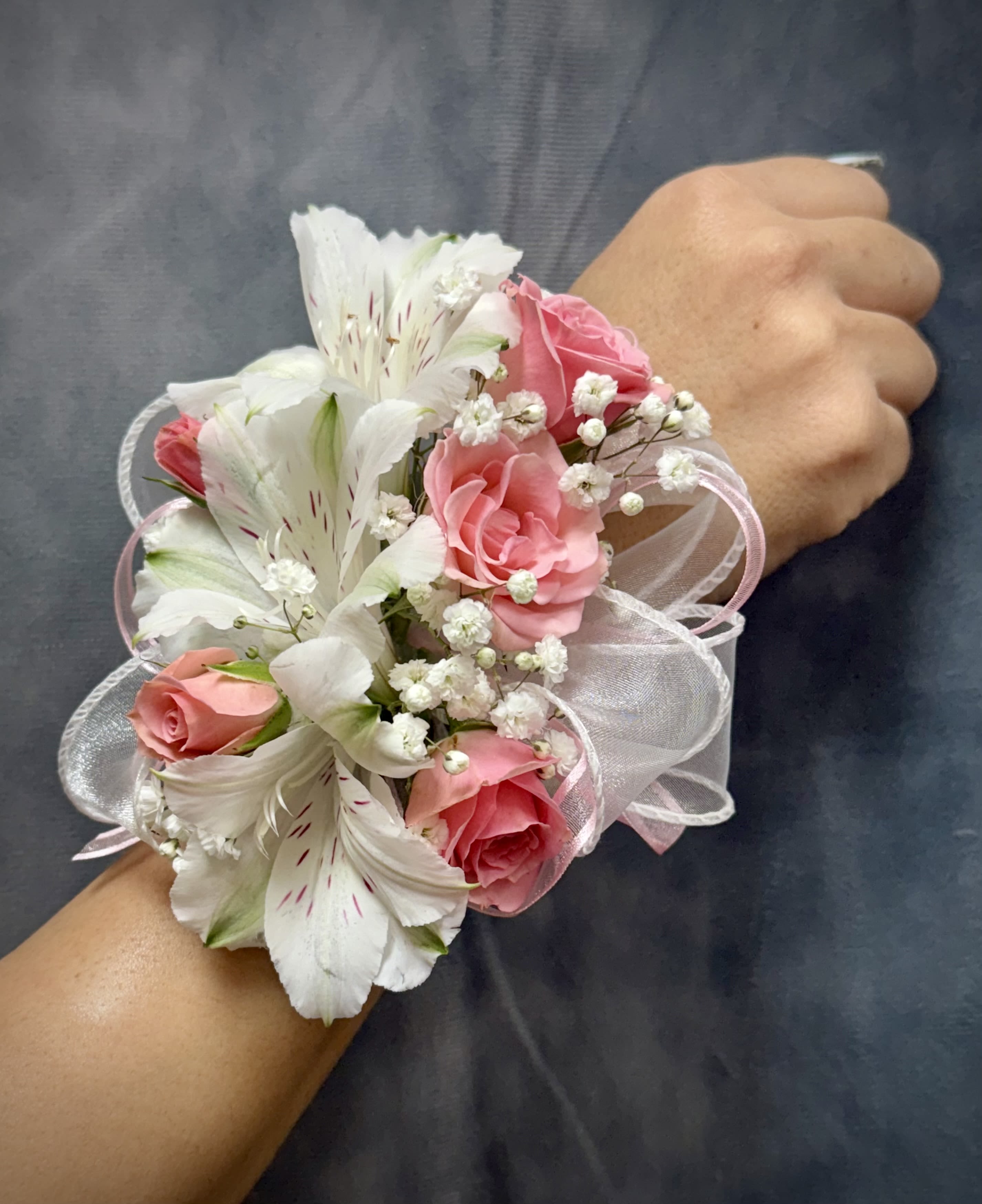 White alstroemerias pink spray roses corsage  - Pink spray roses and white alstroemeria with delicate filler and sheer ribbon on a pearl wrist band corsage perfect for prom 