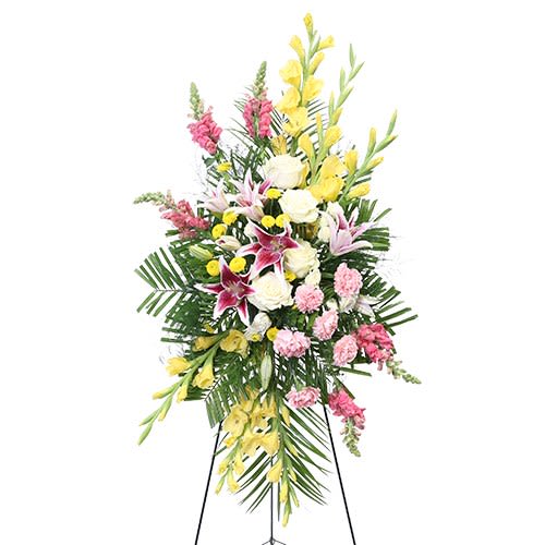 Eternal Glow - A graceful standing spray featuring soft pink lilies, white roses, and yellow blooms, beautifully arranged with lush greenery to express love, peace, and heartfelt remembrance.
