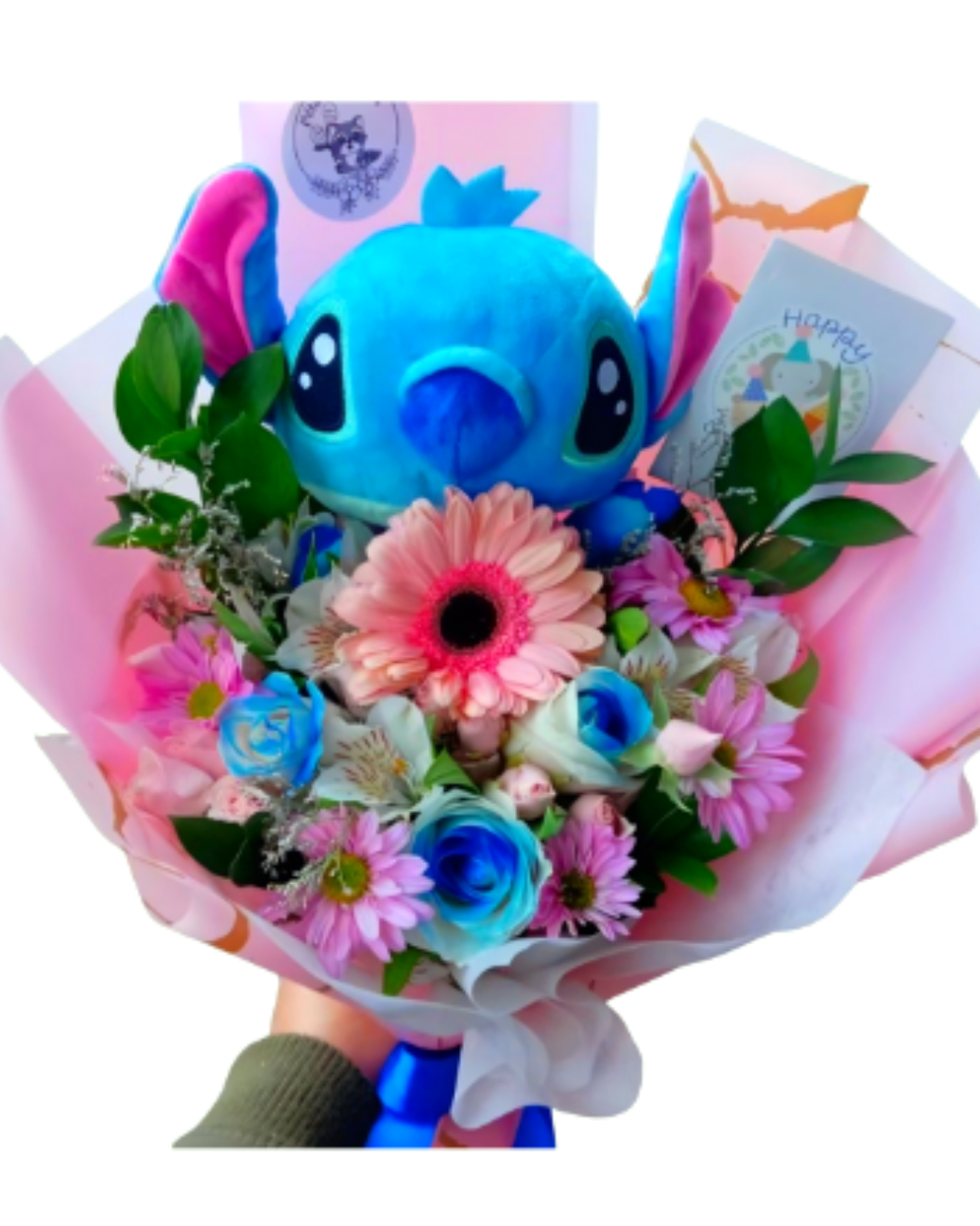 The Ohana Dream Bouquet - The Ohana Dream Bouquet is a dream come true for character lovers. Featuring a lovable blue alien plush, it is surrounded by a charming mix of soft pink gerberas, vibrant sky-blue rose accents, and delicate lavender poms. Handcrafted in Bloomington for unforgettable birthdays or just to say 'Ohana,' this arrangement delivers otherworldly joy in every single detail. "