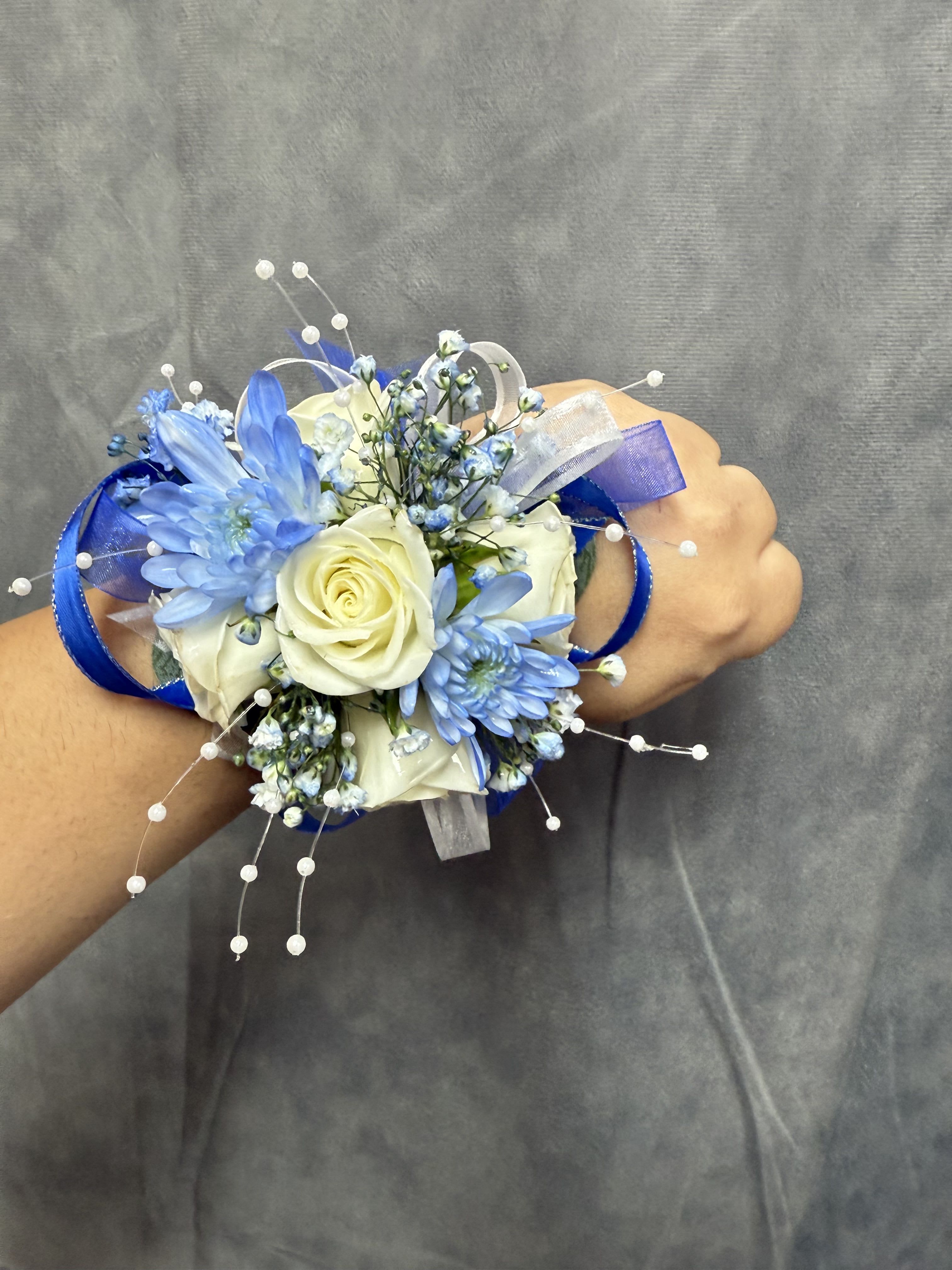 Royal blue white corsage - Royal Blue and white wrist corsage with spray roses, blue accents, finished with satin and organza ribbons, pearl picks on a comfortable pearl wristlet-elegant band perfect for prom