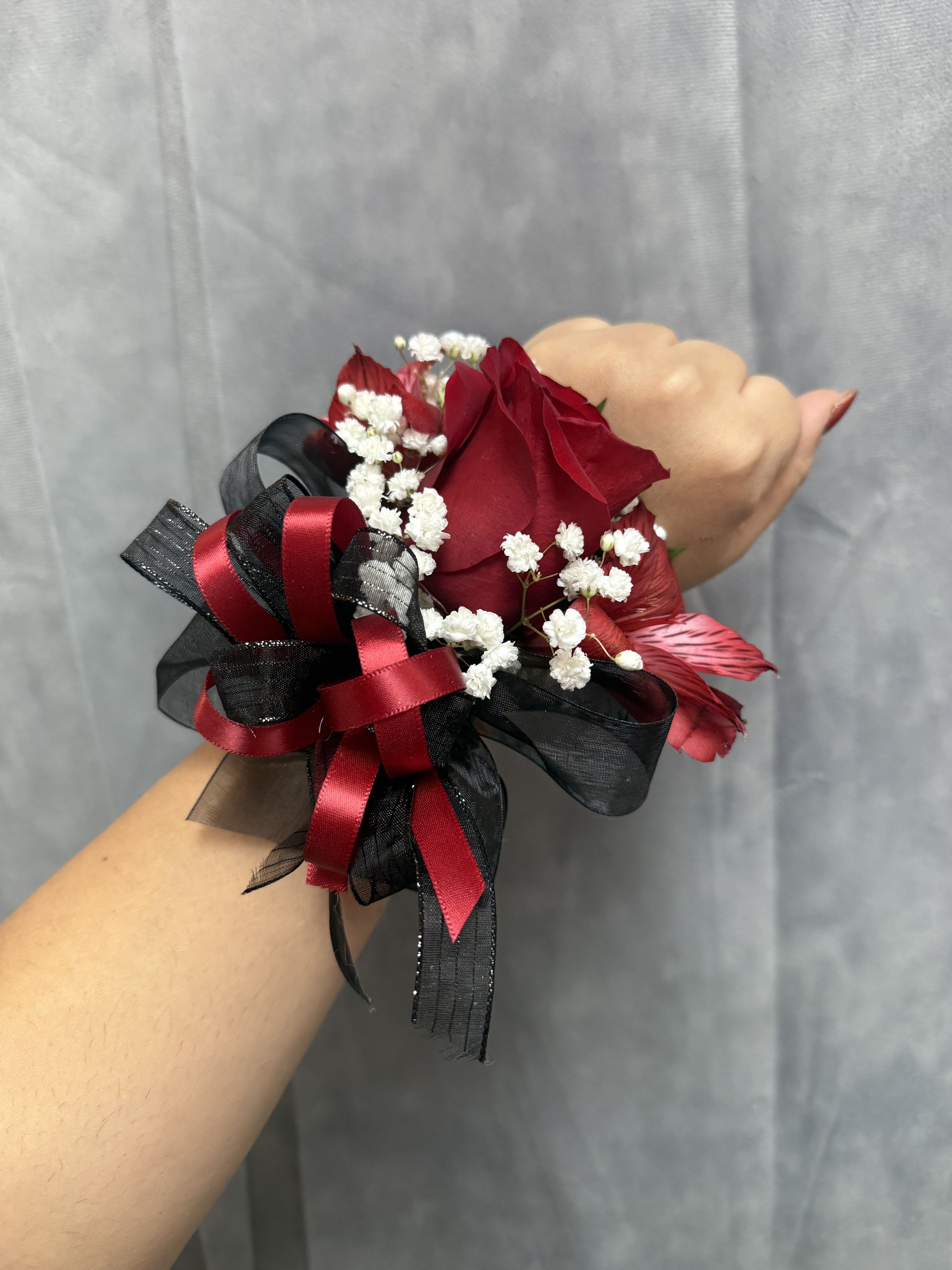 Mix Red rose alstroemerias  corsage - Large red rose with red alstroemerias and  white accents,  and mixed ribbons on a peal wristband perfect for prom