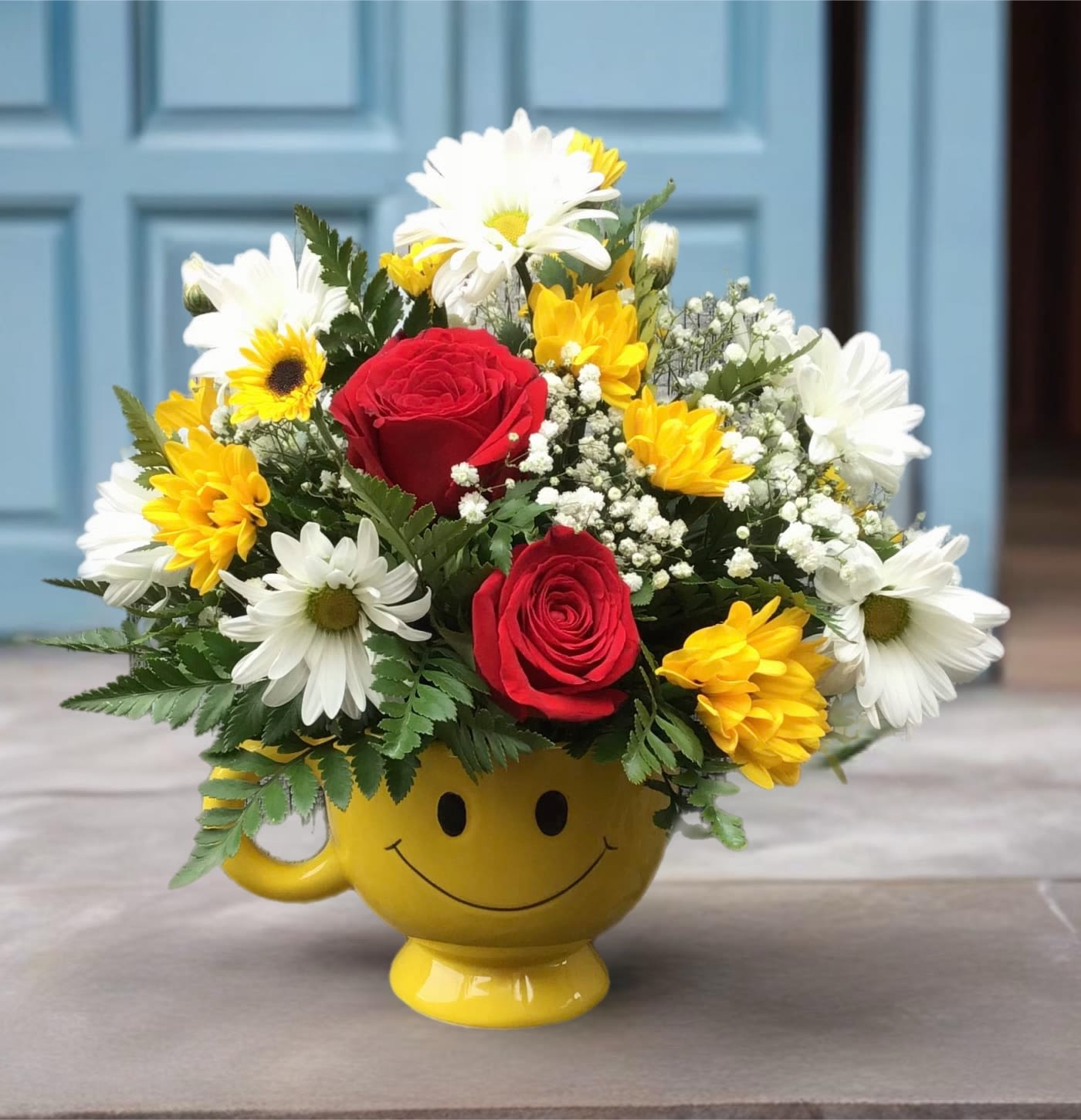 Be Happy Bouquet With Roses - There are probably a million reasons this is such a popular bouquet. Of course, there are probably just as many reasons to send this cheerful arrangement. Full of happy flowers, this ceramic happy face mug will bring smiles for years to come. Especially when filled with that first cup of morning coffee or cocoa!