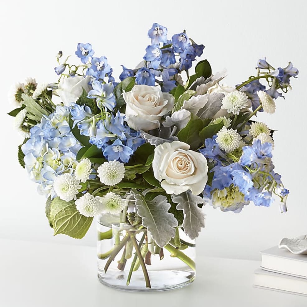 Blue and white flower arrangement in a clear glass vase