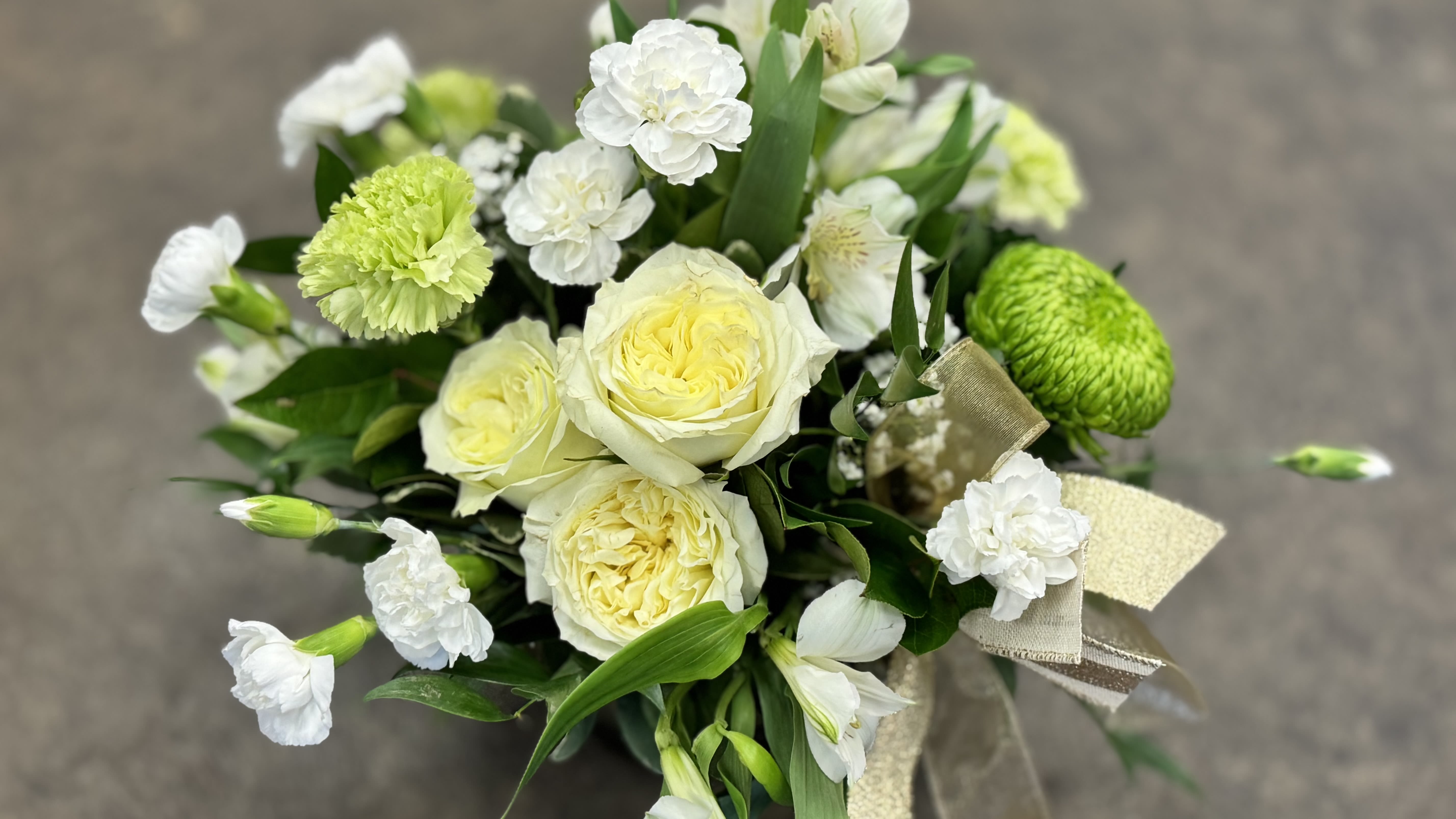 Emerald Garden - Soft, fresh, and full of life—this garden-inspired arrangement captures the feeling of spring in bloom. Creamy roses, delicate white flowers, and vibrant green accents are thoughtfully gathered with fresh foliage to create a look that feels effortless and full of heart. Arranged in a modern glass vase, it’s a beautiful way to celebrate Mom and everything she brings to your life.