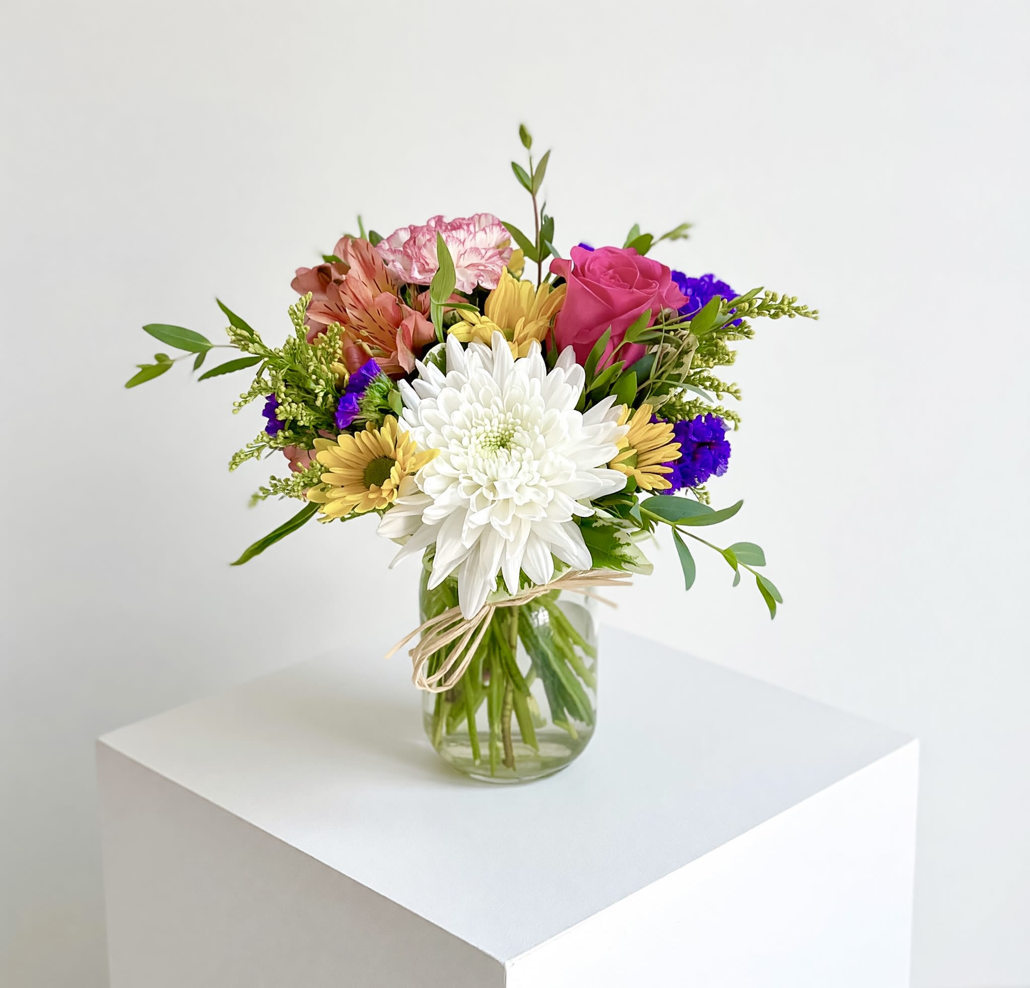 Small Garden Jar  - A small 16oz mason jar filled with bright spring colors! A cremon, carnation, alstroemeria, rose, daisies, and statice make up this cute little arrangement. 