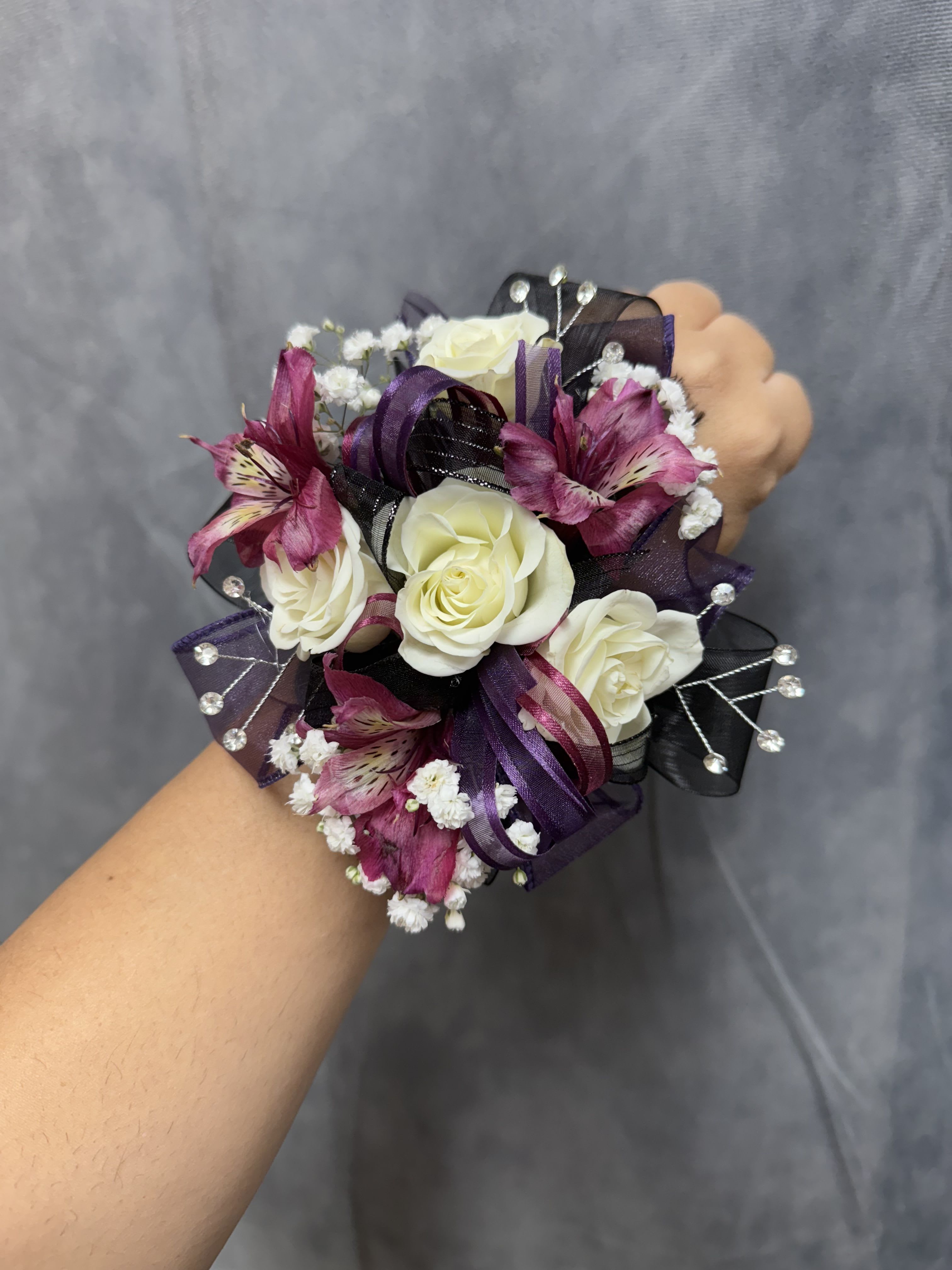 White plum purple black corsage  - White spray roses with plum alstroemeria and purple and black ribbons and rhinestone on pearl wrist band  corsage perfect for prom
