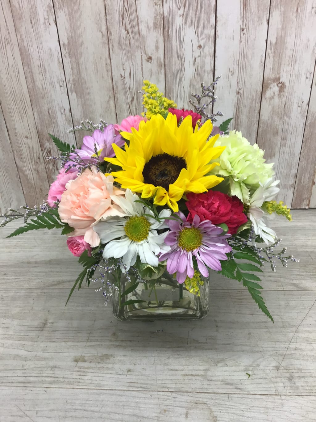 Mixed bouquet with a sunflower in a glass vase