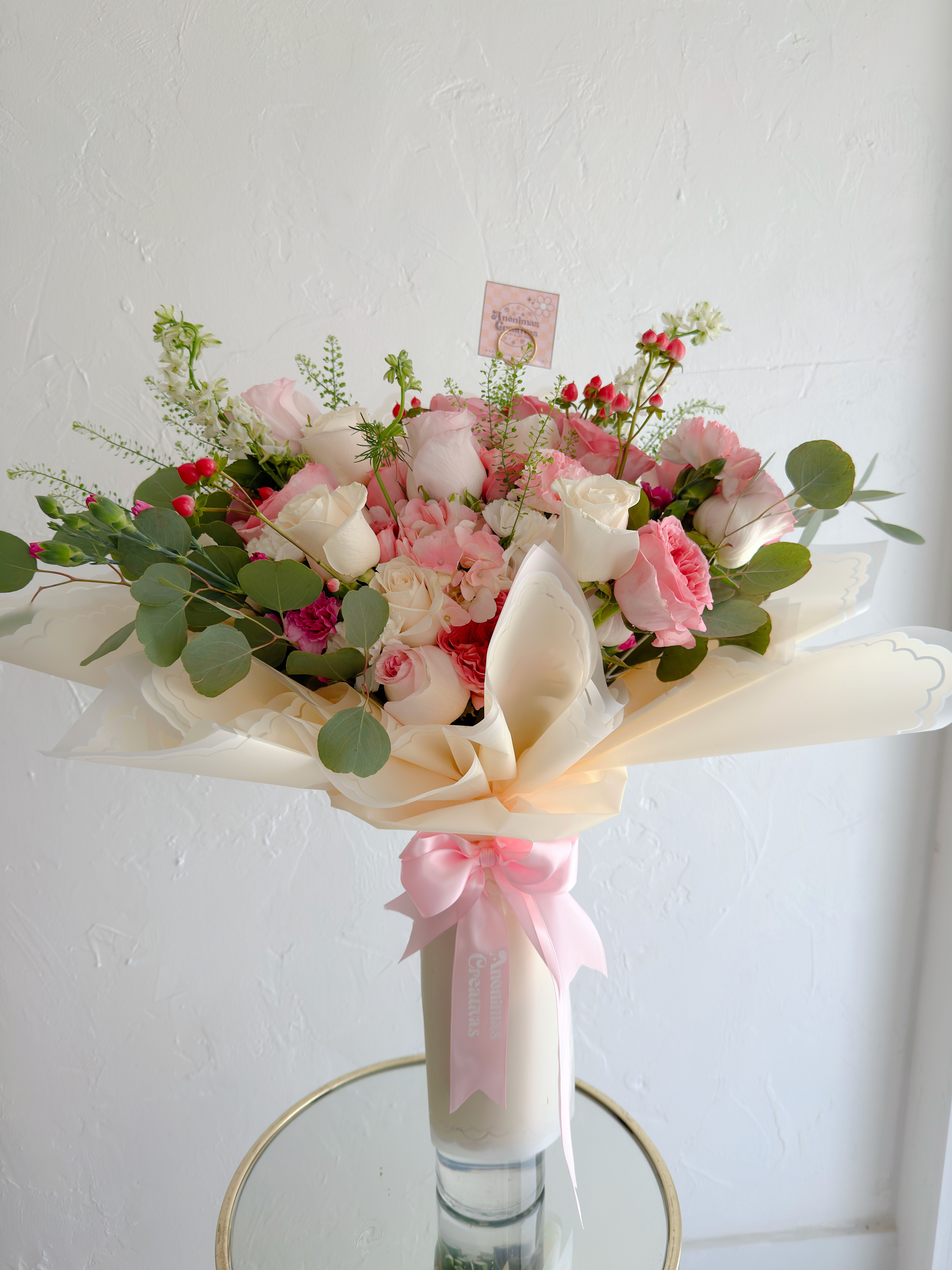 Bouquet Amaia  - Elegant and romantic bouquet featuring a soft mix of blush and white roses, complemented by delicate filler flowers, hypericum berries, and fresh eucalyptus. Wrapped in premium cream-toned paper and finished with a satin ribbon, it’s a graceful and feminine design—perfect for special occasions or heartfelt gifts. 