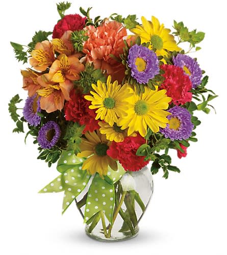 Colorful mixed bouquet in a clear glass vase with a polka-dot ribbon