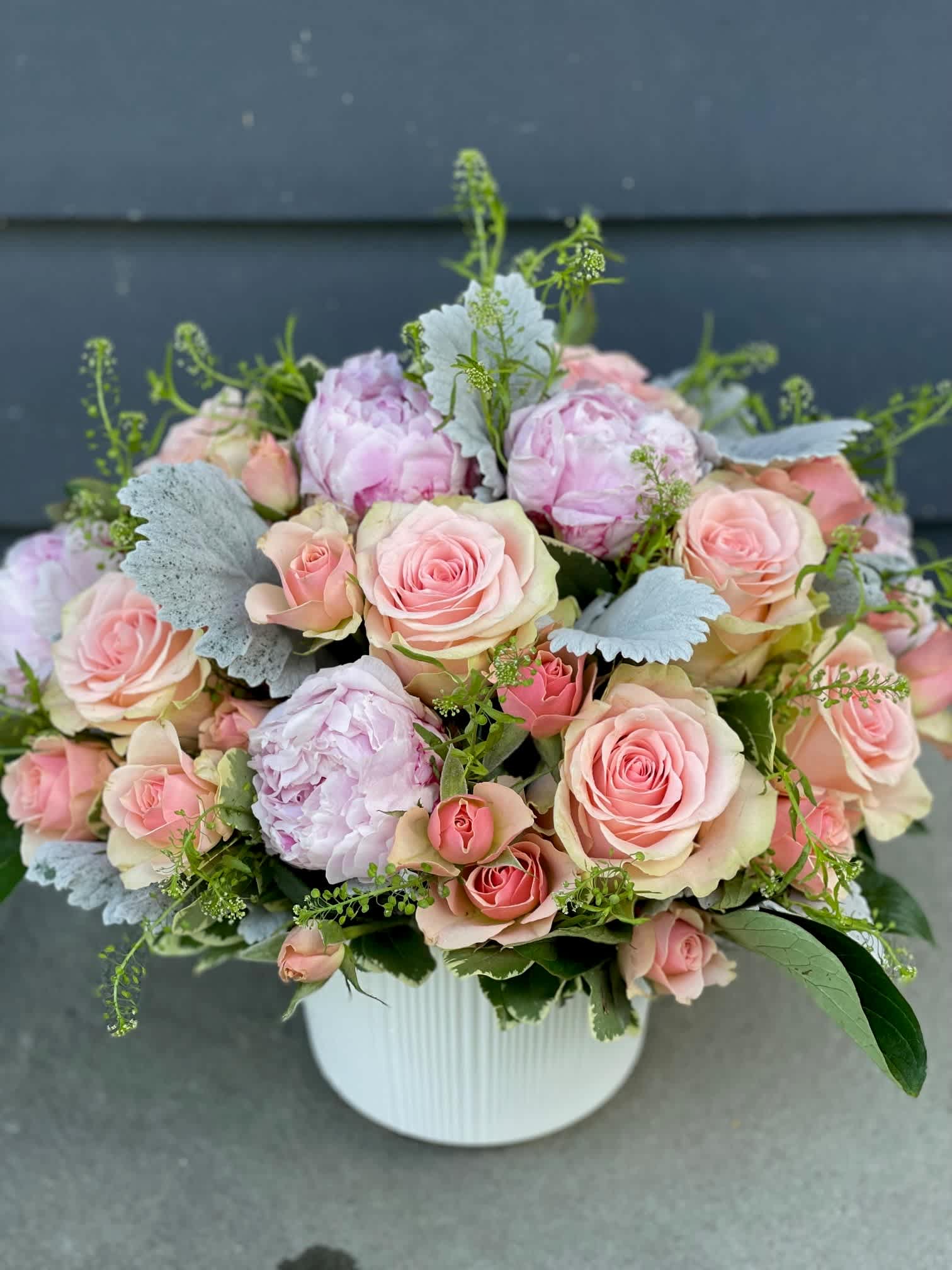 Pink roses and peonies arranged in a white vase