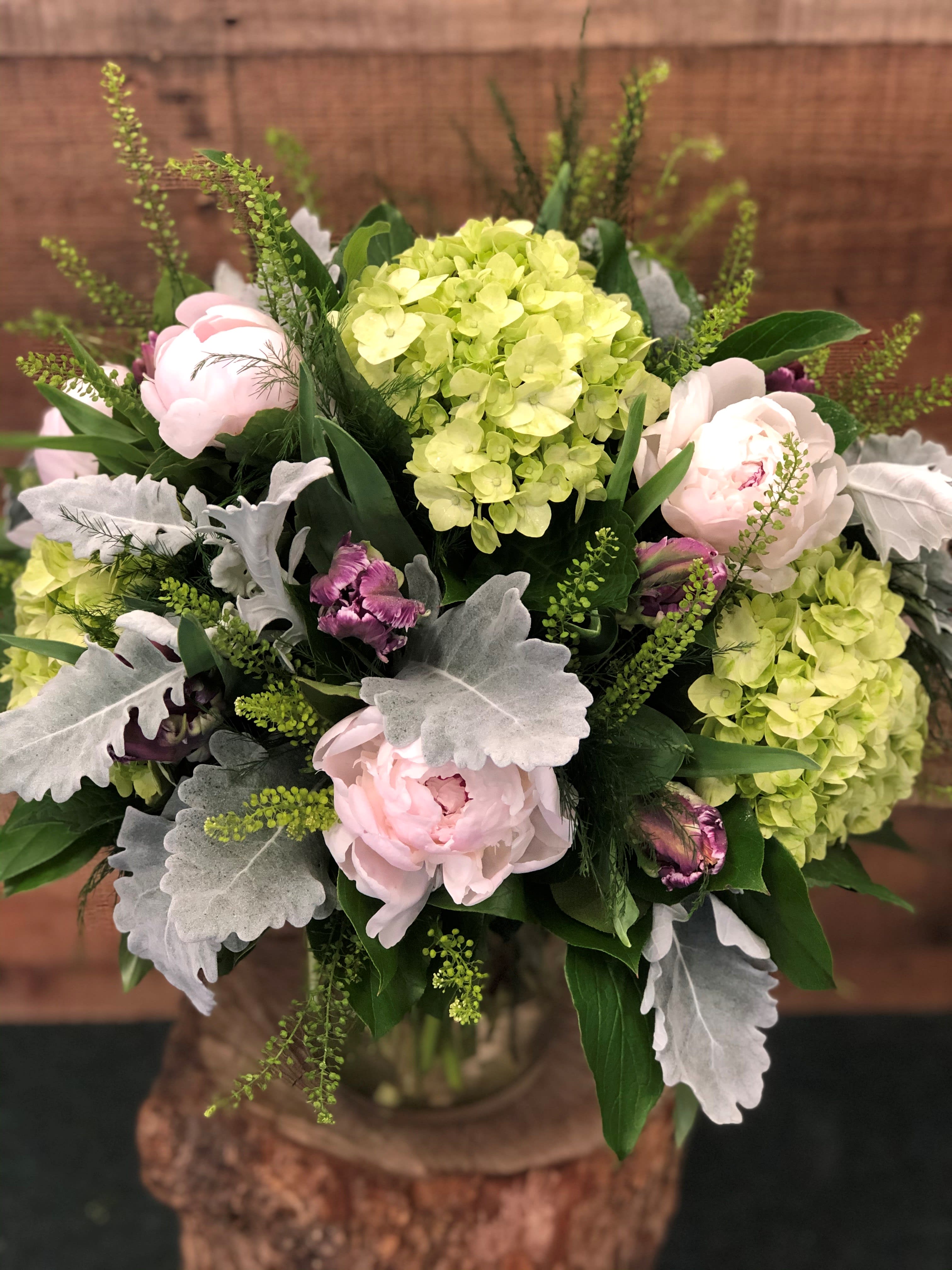 Bouquet of pale pink peonies and lime hydrangeas with silver foliage