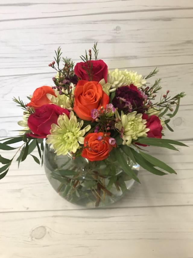 Warm Wishes - Bubble bowl filled with colorful roses, carnations, pomps and mixed greenery. 11 1/2" H x 12" W