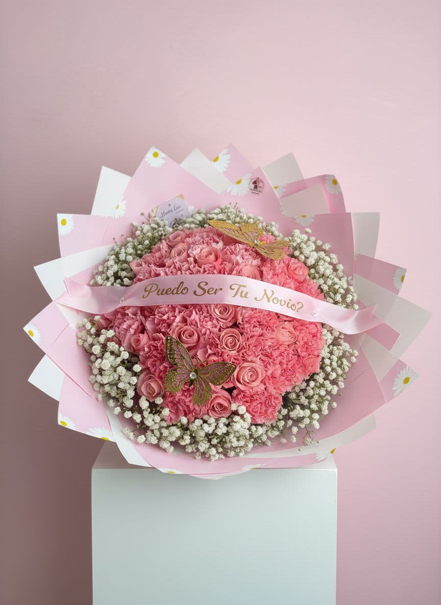 Puedo Ser Tu Novio Pink Rose Bouquet - Make your moment unforgettable with our “Can I Be Yours?” Luxury Proposal Bouquet   This stunning, handcrafted arrangement features a full, romantic design with pink roses, carnations, baby’s breath, and delicate butterfly accents, wrapped in premium blush-toned paper for a soft and elegant presentation. Finished with a customizable ribbon message, this bouquet is designed to turn a simple question into a beautiful memory.  Perfect for proposals, asking someone to be your girlfriend, anniversaries, or romantic surprises.   Personalize it: Add your own custom message to the ribbon for that extra special touch.  Please note: Flower shades, butterfly accents, and wrapping may vary slightly based on availability while maintaining the overall design and color palette.