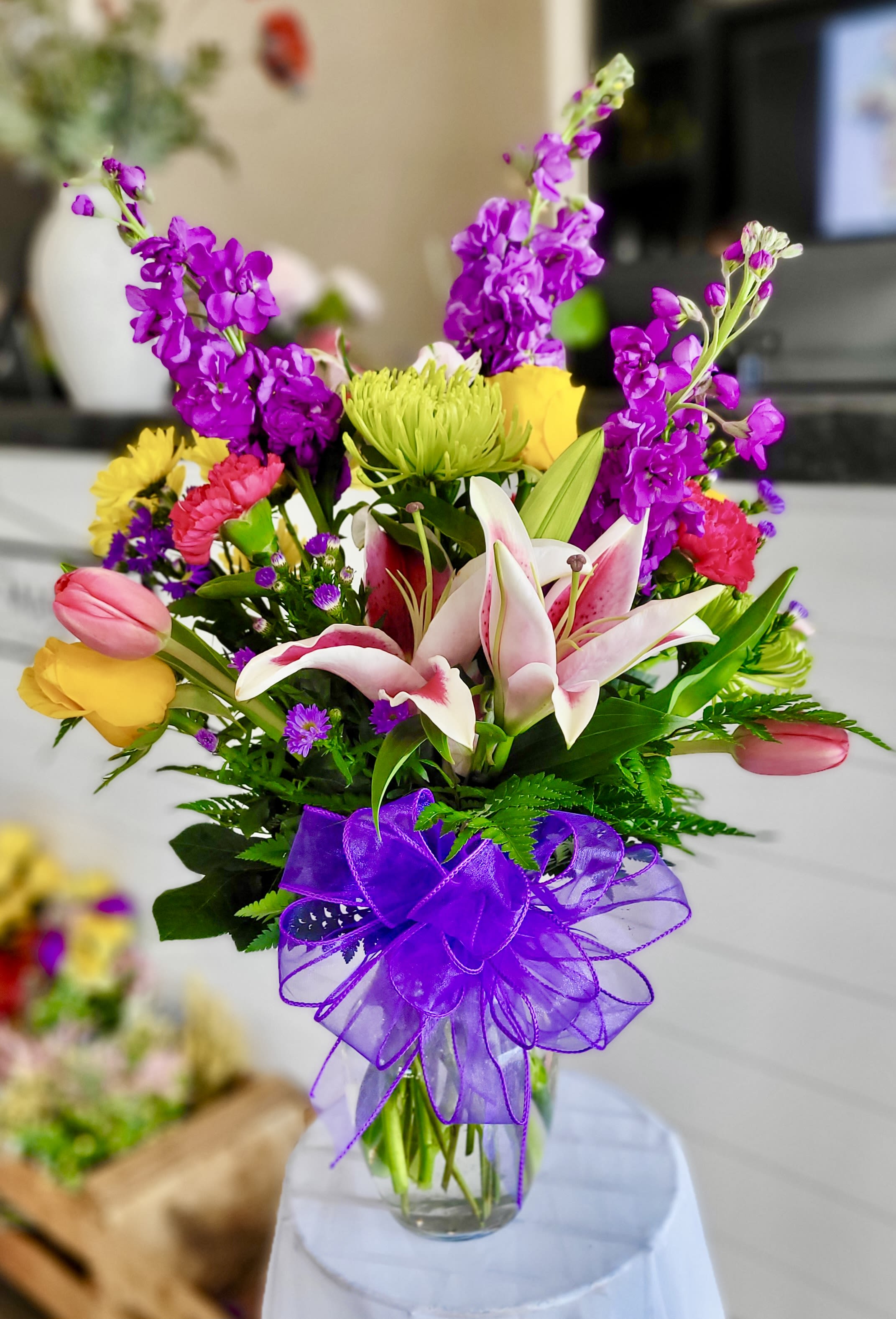 A Mom like no other - Celebrate the extraordinary mom in your life with this stunning flower arrangement! Bursting with vibrant purple stock, cheerful yellow roses, delicate pink tulips,  green Fuji mums, and beautiful stargazer lilies, this bouquet makes a breathtaking statement. Keep in mind that during the holiday season, we may need to substitute certain flowers or colors to ensure your gift is just as special. Treat her to a beautiful surprise she won't forget!