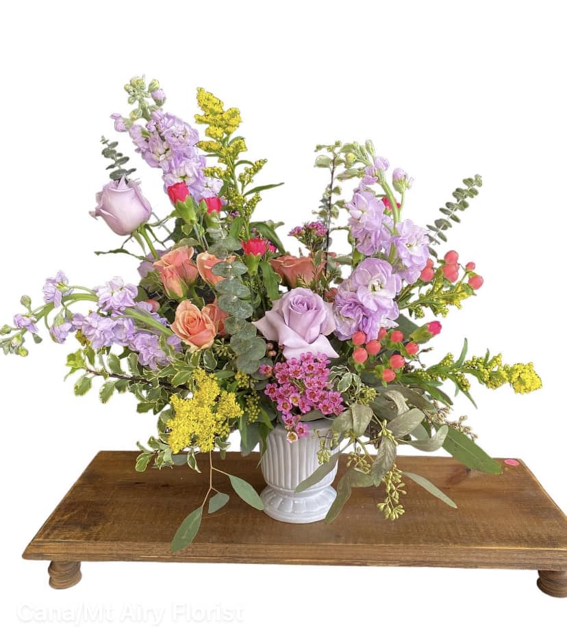 Mixed bouquet in a white vase with lavender, peach, pink, and yellow flowers