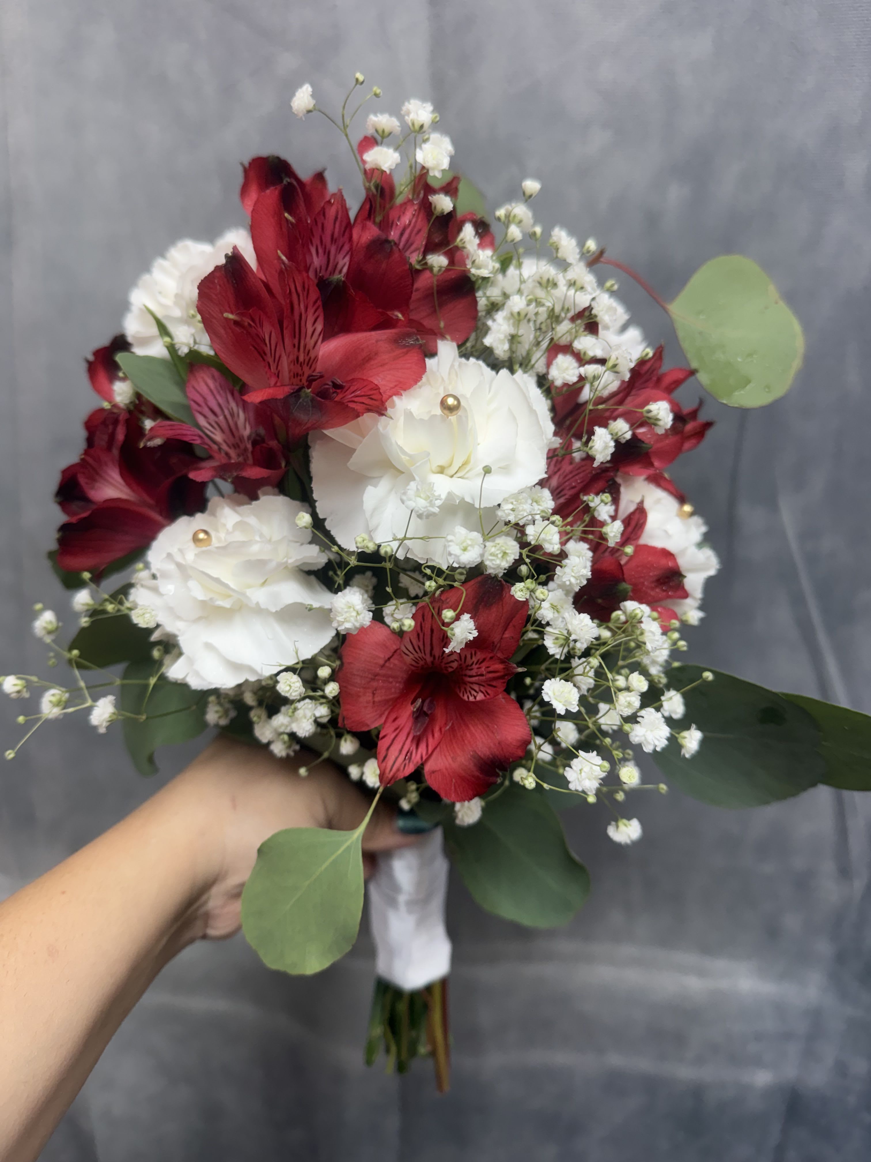 White carnation red prom bouquet  - Red alstroemeria and white carnations with soft green and gold pins. Beautifully wrapped perfect for prom