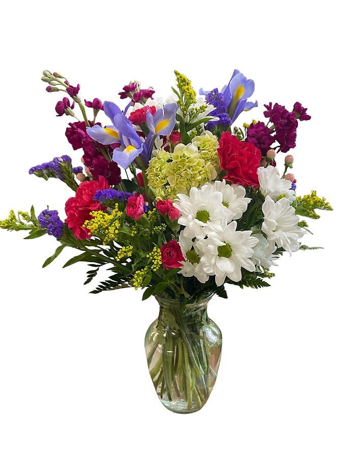 Mixed bouquet of purple, white, pink, and yellow flowers in a glass vase