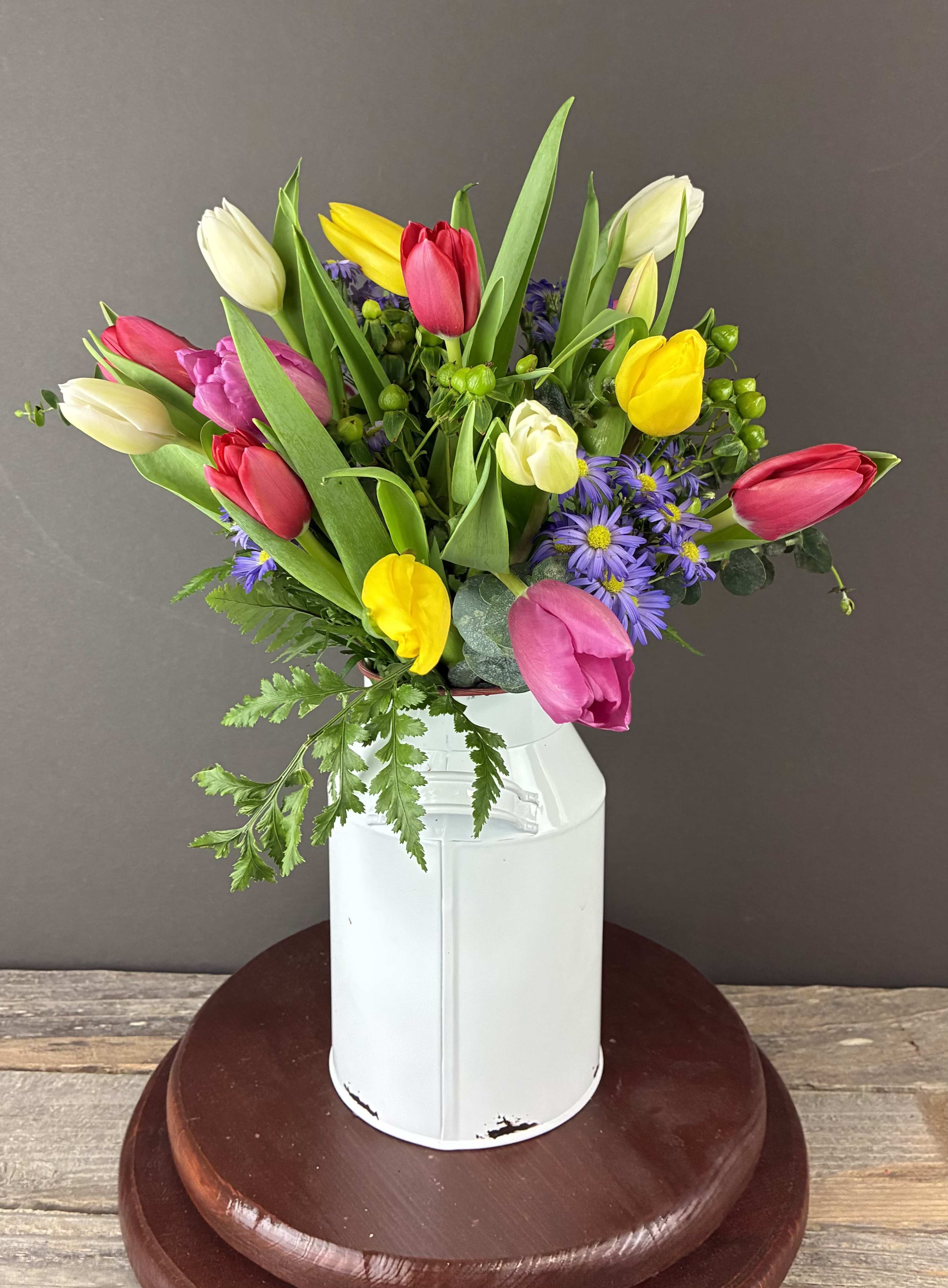 Colorful tulip bouquet in a white metal vase