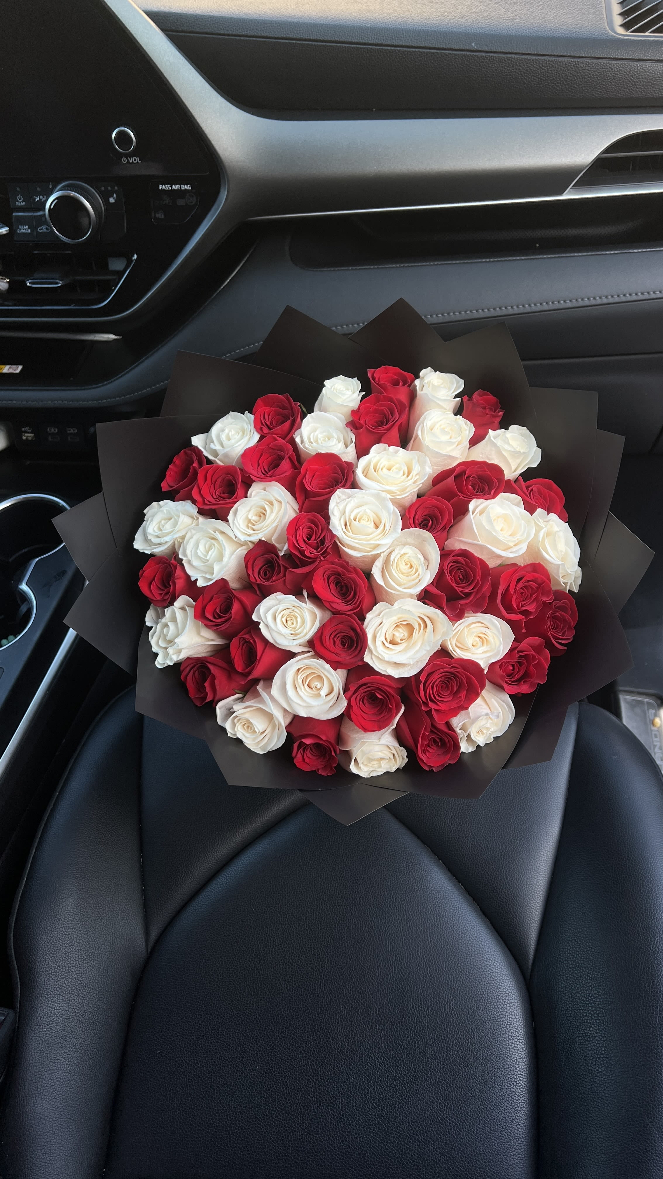 Bouquet of red and white roses wrapped in black paper