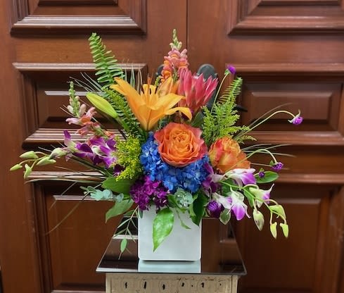 Feels like summer - Recipe: Lilies, Dendrobium Orchids, Snapdragons, Hydrangae, Roses, Sweet William and more in a square, white vase. Seasonal: All year round Orientation: Front Facing View Photo shown: Standard 