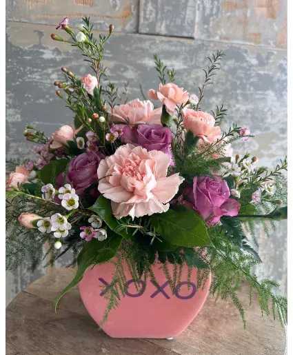 XOXO Conversation Heart Valentines Arrangement - Pink and Purple carnations with pretty wax flowers arranged in a "XOXO" pottery conversation heart vase.