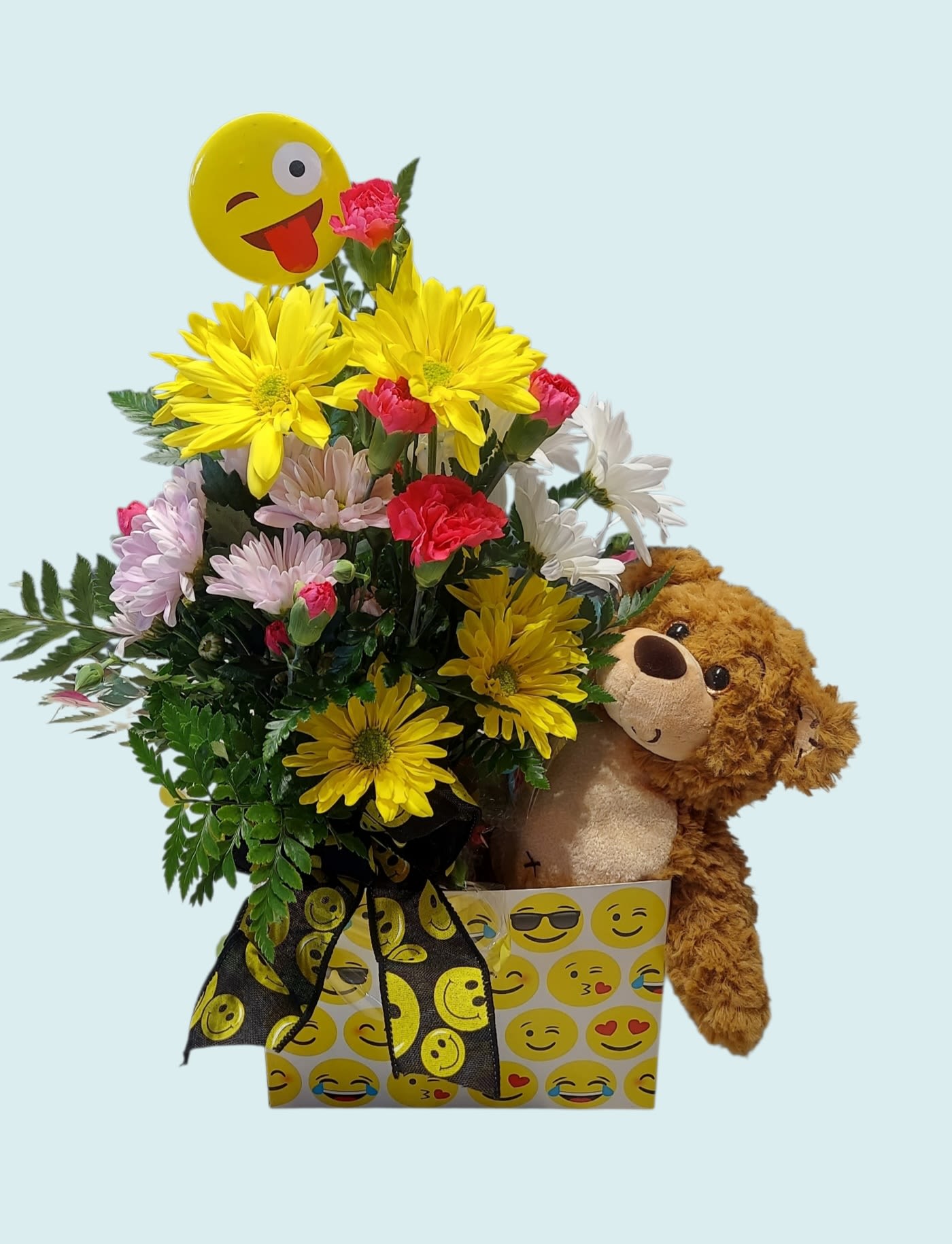 Bouquet of yellow, pink, and white flowers with a teddy bear and emoji balloon