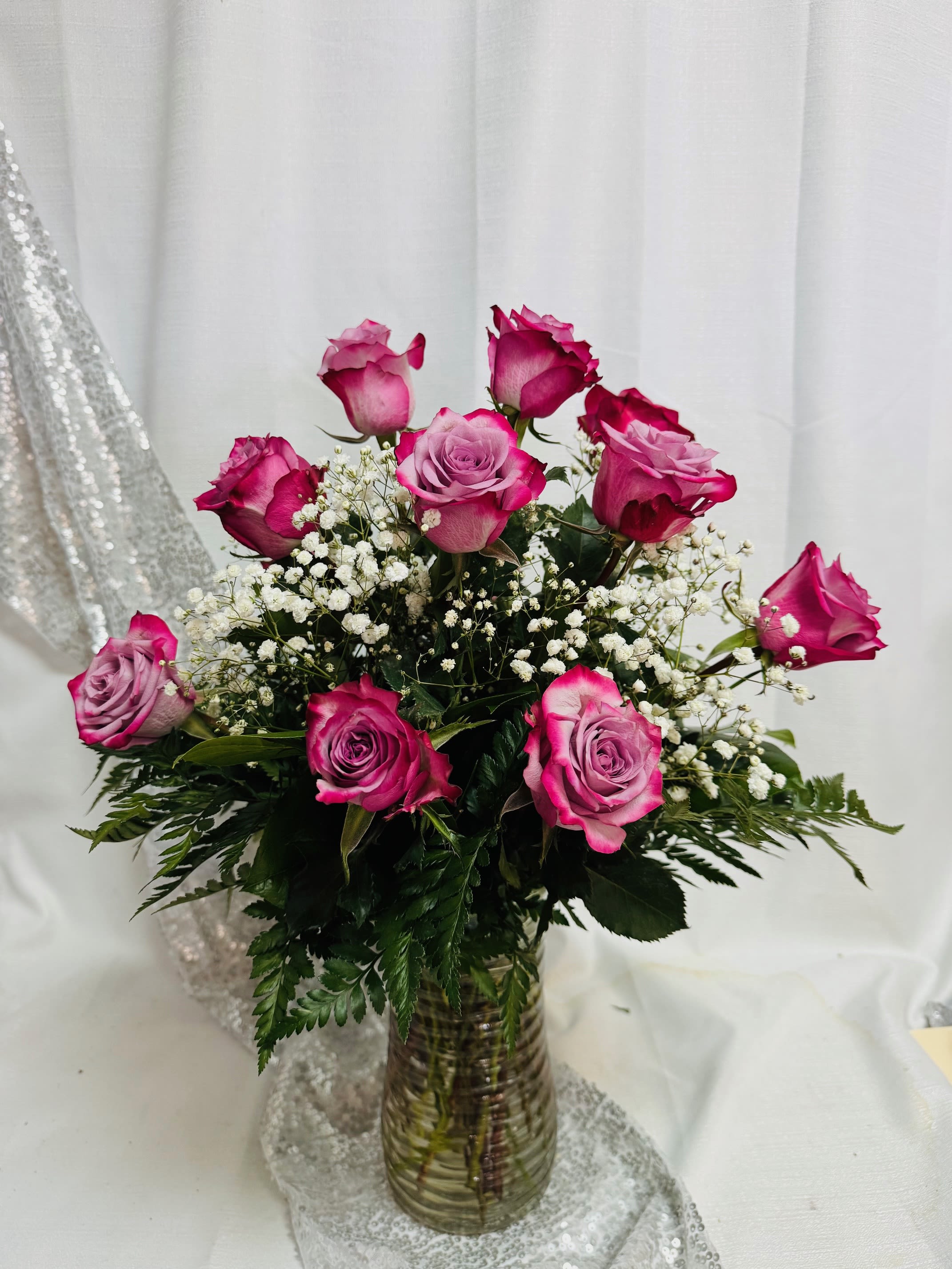 1 Dozen Lavender Roses with Baby's Breath - Vivid lavender roses form a beautiful bouquet designed to make the person you're thinking of feel truly cherished. This flower arrangement for birthdays, love and romance, or a thoughtful "thinking of you" gift also works beautifully for Mother's Day-its classic color combo reads both celebratory and intimate, the kind of bouquet that says "you matter" without words.  Perfect for sending to a mom or close friend, this arrangement arrives ready to display and brighten a room. For best enjoyment, place in fresh water away from direct heat and change the water every 2-3 days to keep the roses looking their freshest.