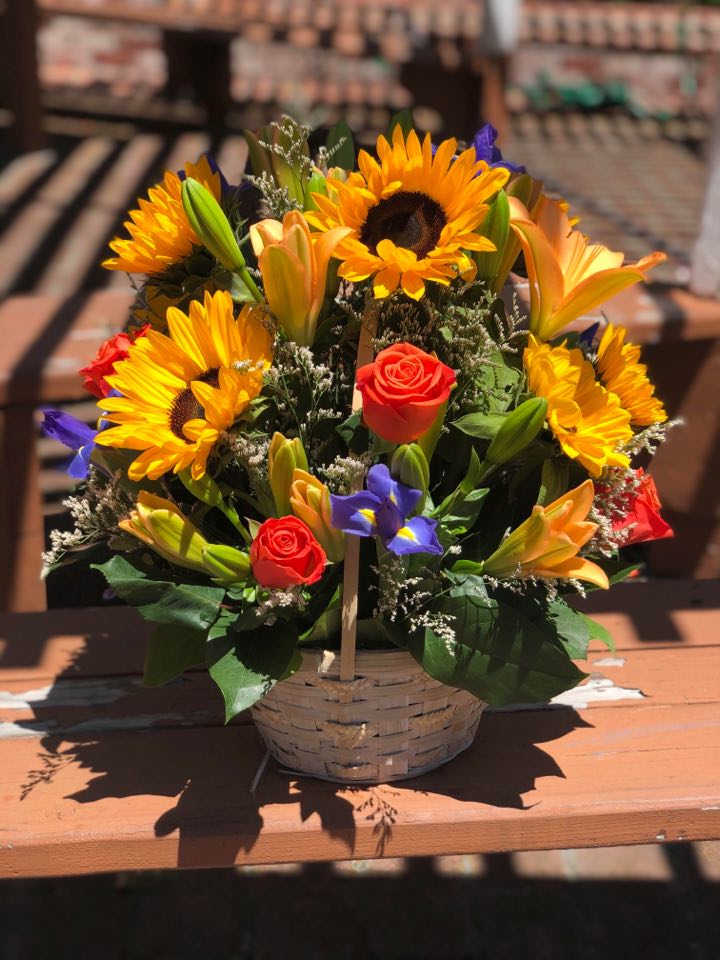 Basket arrangement with sunflowers, roses, and lilies