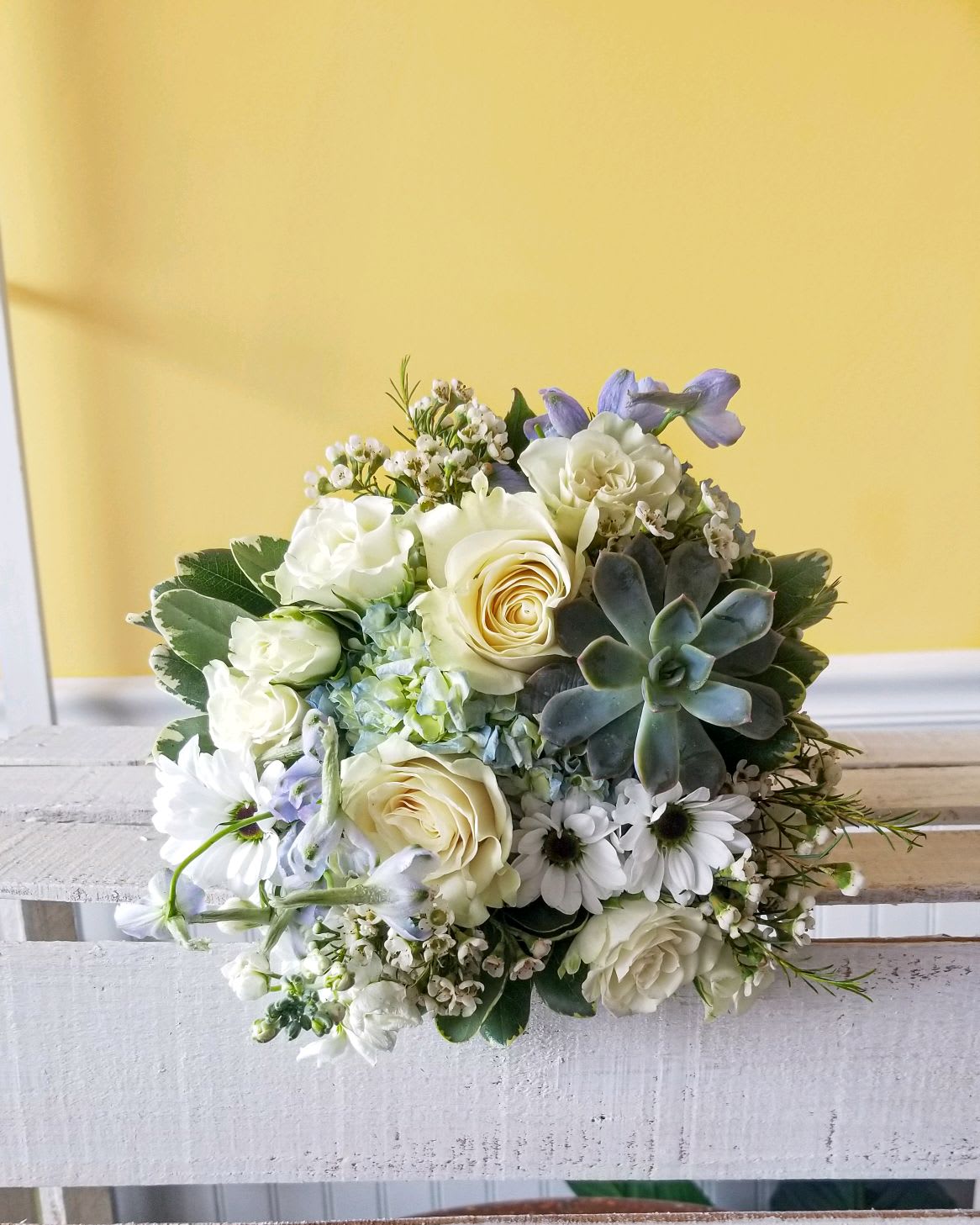 White rose bouquet with daisies and a succulent