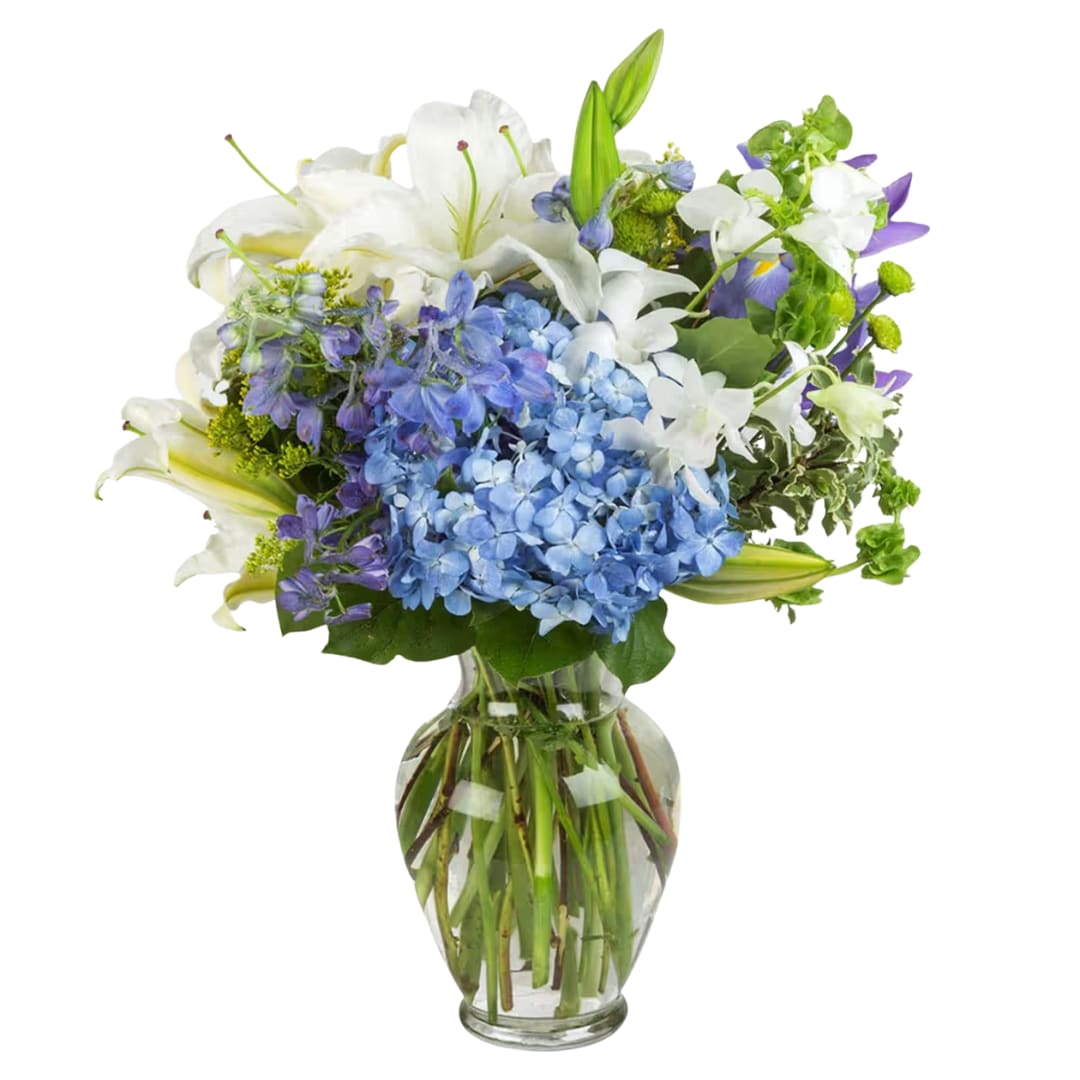 Breezy by the Sea  - This arrangement contains delphinium, asiatic lilies, hydrangea, alstroemeria, blue iris, and other seasonal blooms. It is a great gift for a birthday, get well, for wishing someone a fresh start. APPROXIMATE DIMENSIONS: 15" D x 18" H