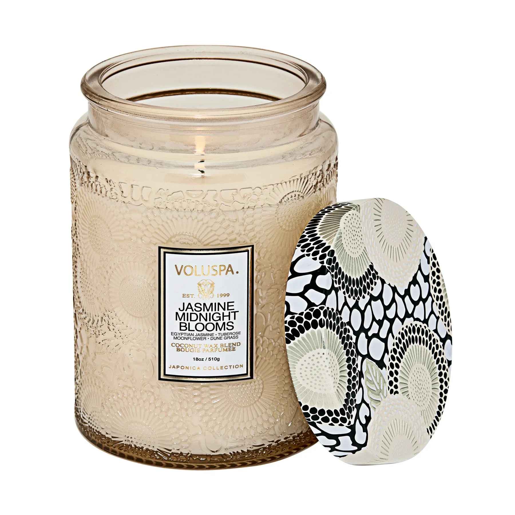 Voluspa Large Jar Candle - Jasmine Midnight Blooms - Fragrance Family: Floral Notes of Egyptian Jasmine, Tuberose, Moonflower &amp; Dune Grass. The rising moon awakens the blooms from their slumber with spells of Italian Bergamot and Moonflower. Arousing notes of Egyptian Jasmine and Tuberose overtake the senses, illuminating their long stems and arching petals. Blossoming with a bravado of Dune Grass and Mango Wood, the ladies of the night arrive in full bloom, sending fragrance throughout the night air like sweet secrets kissing the ear. A bold fragrance, as intense as its beauty. Voluspas unique coconut wax blend is hand-poured into a 18 oz. embossed glass vessel and is topped with a metal lid, adorned with Japonica detailing that keeps the candle dust-free when not in use. The single wick allows you to enjoy fragrance throw for 100 hours. Our candles are hand-poured in the United States and feature our proprietary, clean-burning coconut wax blend and 100% natural wicks. Our products are free of phthalates, pesticides, parabens and sulfates and are never tested on animals. Up-cycle this best seller into a keepsake after the last burn.