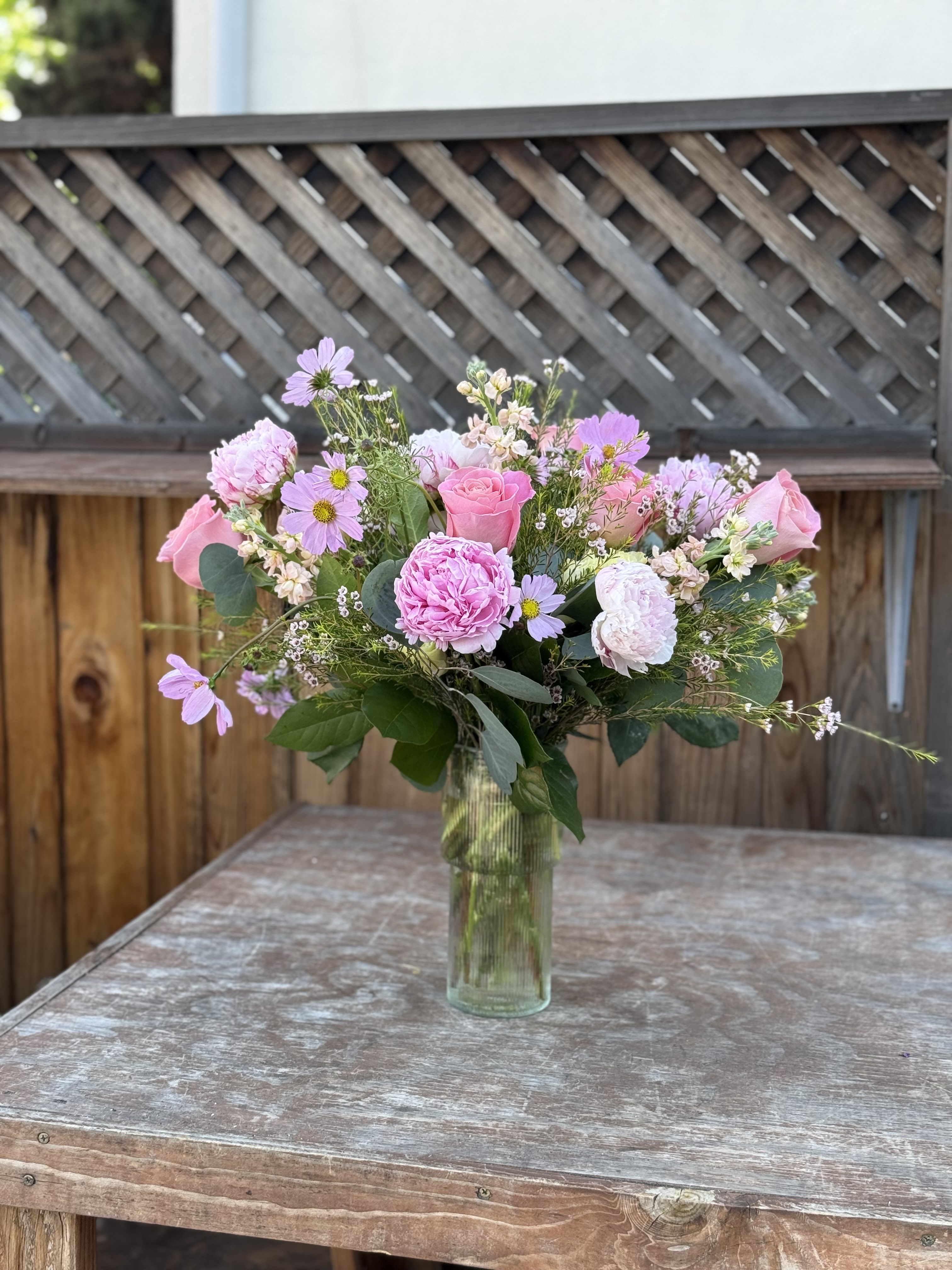 Culver bloom - An arrangement of peonies, roses, in season flowers and greenery. In glass vase 