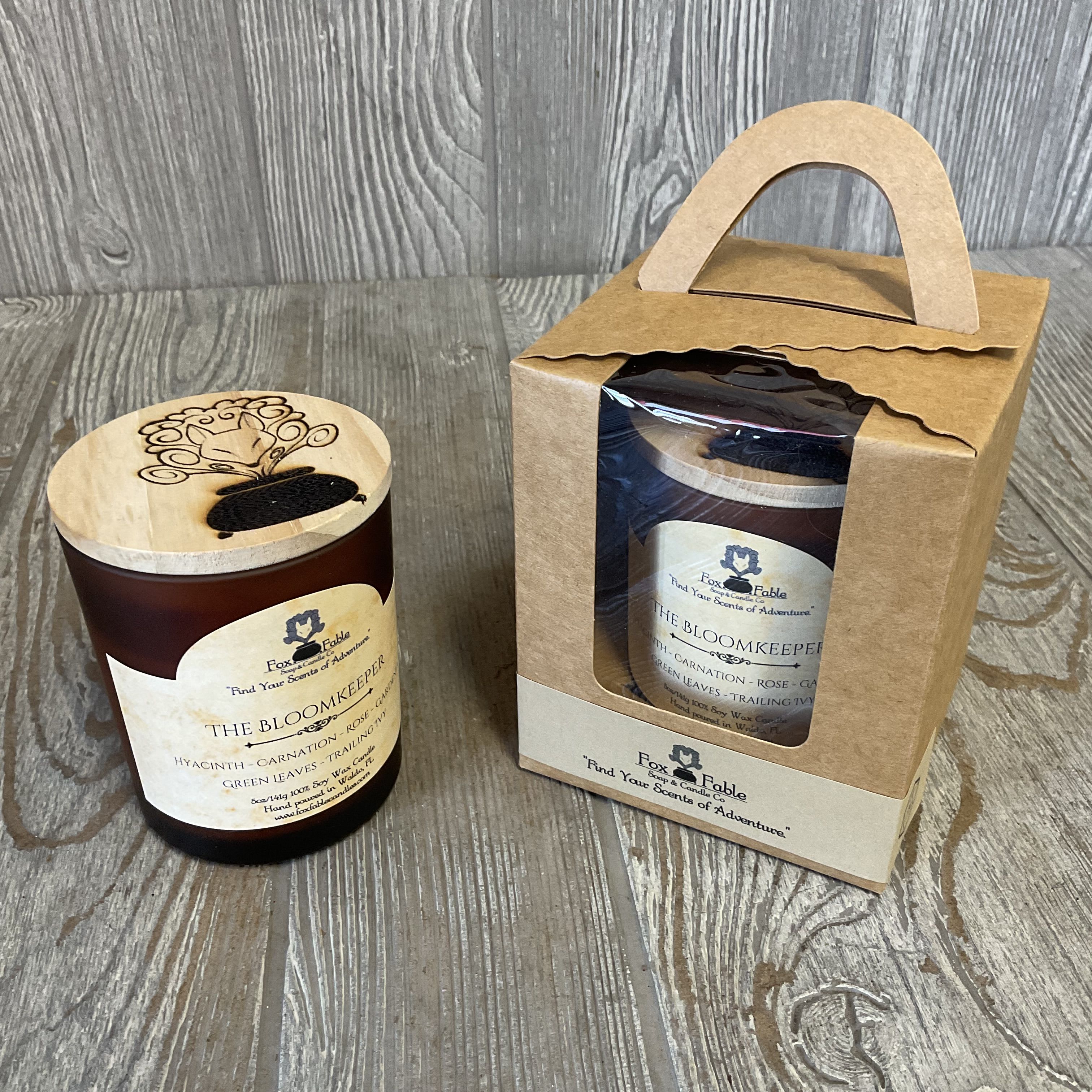 Two packaged candles in brown containers with wooden lids