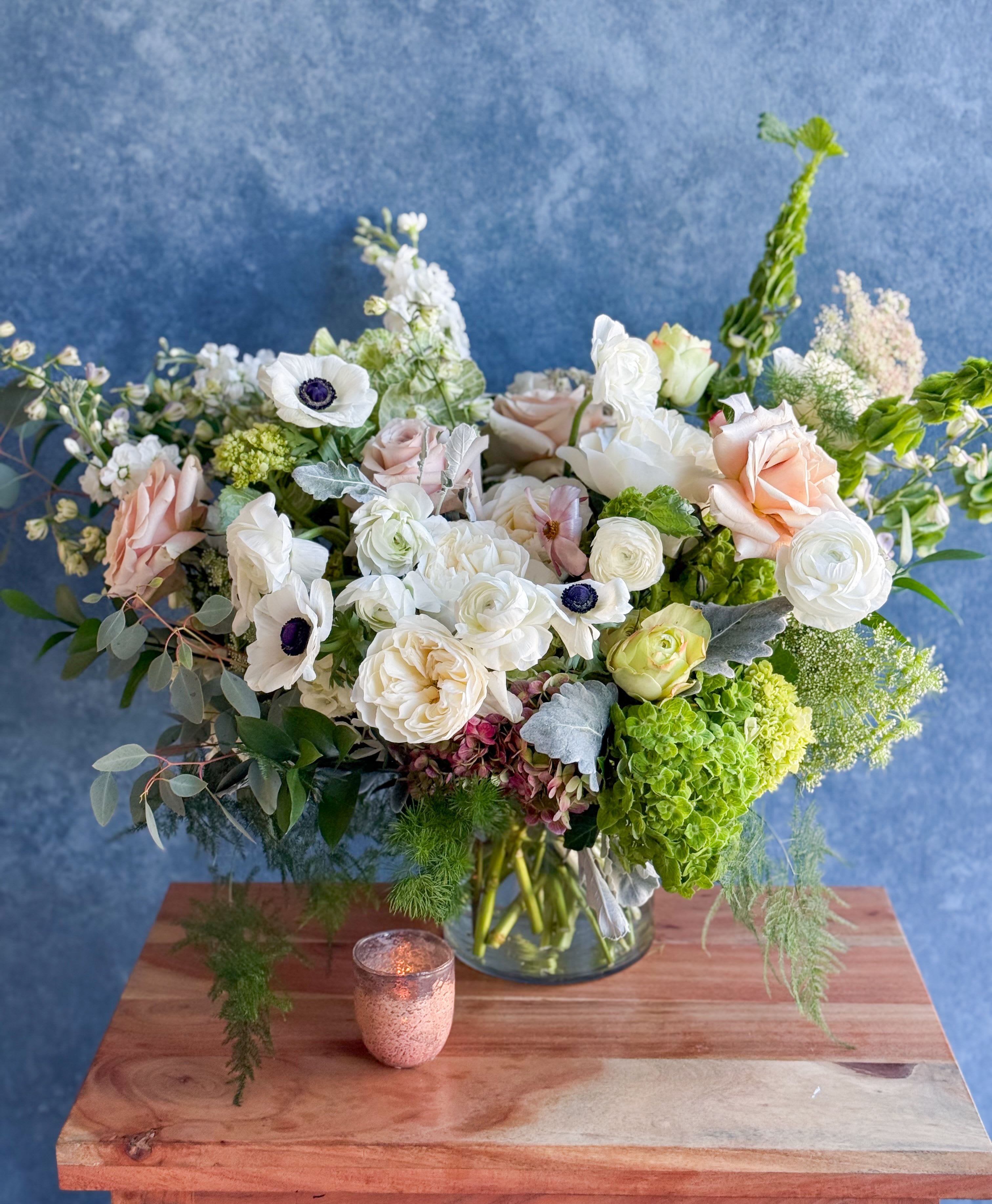 Mixed bouquet of white and blush flowers in a glass vase