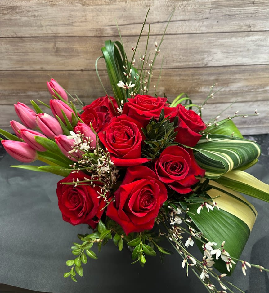 Roses &amp; Tulips - Wow your Valentine with a beautiful arrangement of 12 premium red roses and tulips!  Arranged in a clear glass cube accented with eucalyptus and tropical leaves!  Sure to make an impression!  Measures: 10" wide x 12" tall 
