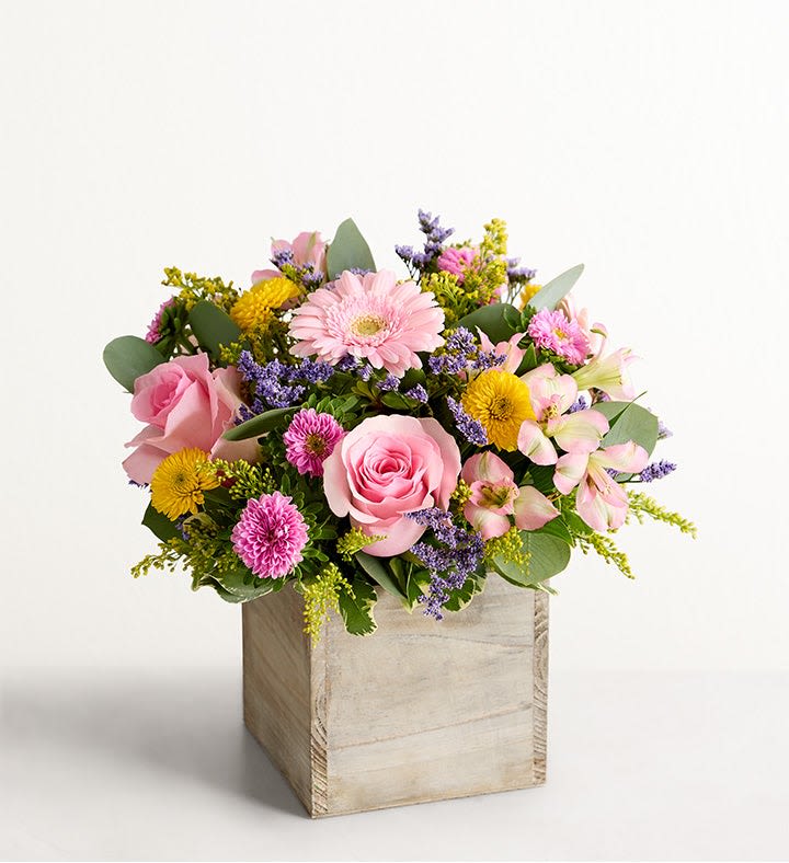 Spring Sentiment Medley - Spring is a time to refresh and reach out. Our spring bouquet celebrates that sentiment. Pastel pink and yellow blooms are loosely gathered with lush greenery for style and texture. Designed in our rustic, gray-washed wooden cube, it’s a gift that delivers on your feelings in the most beautiful way.